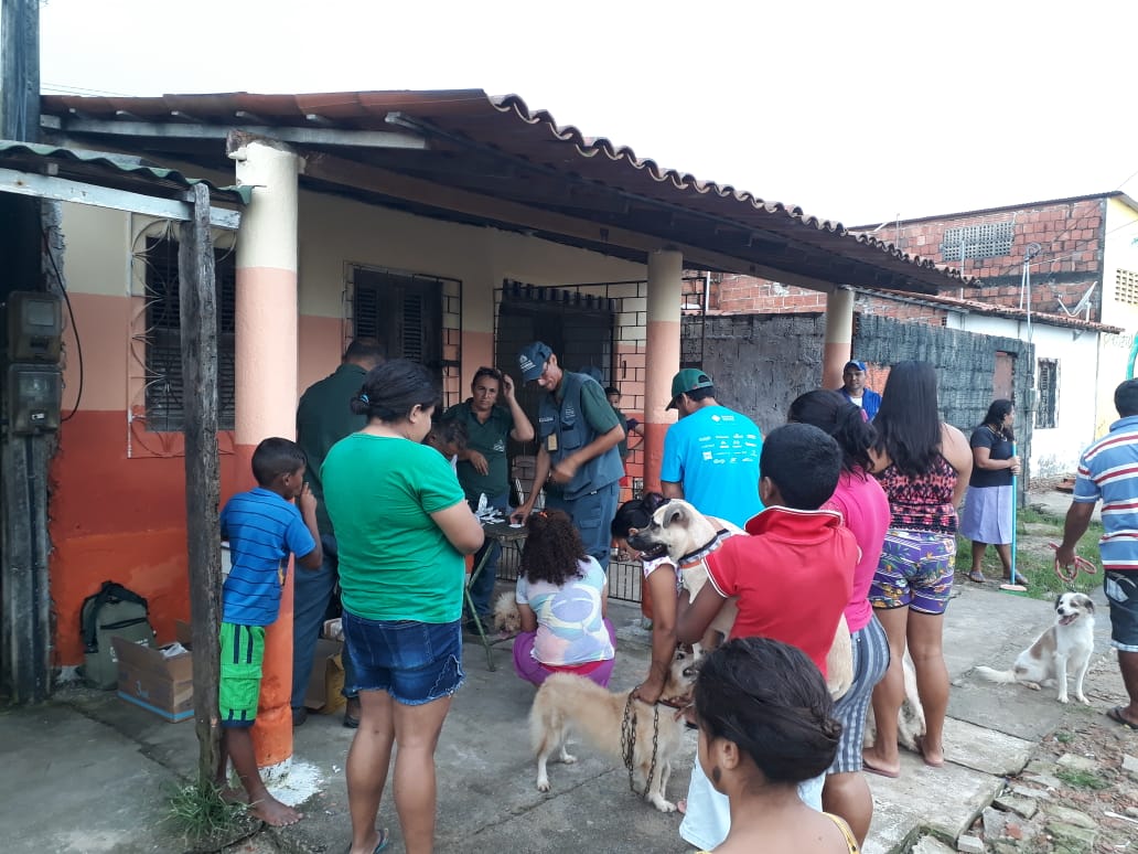 Pessoas em fila para receberem atendimento em comunidade