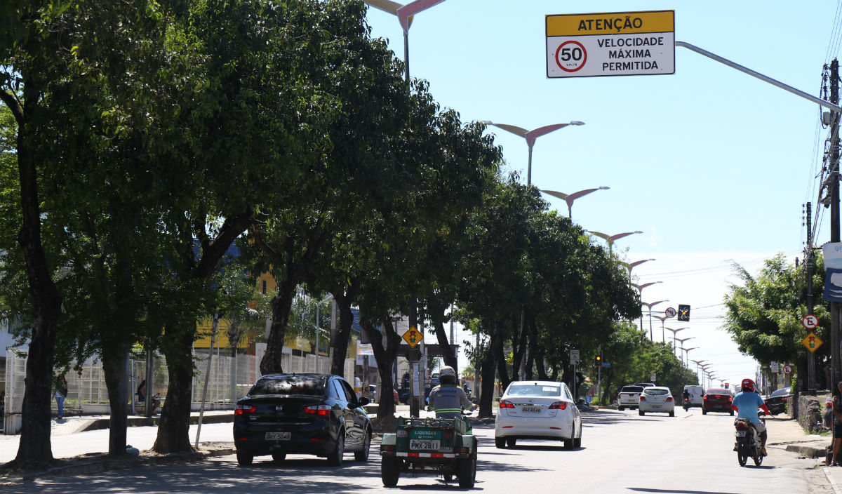 Avenida com carros e motos passando e placa de velocidade máximo 50km/h