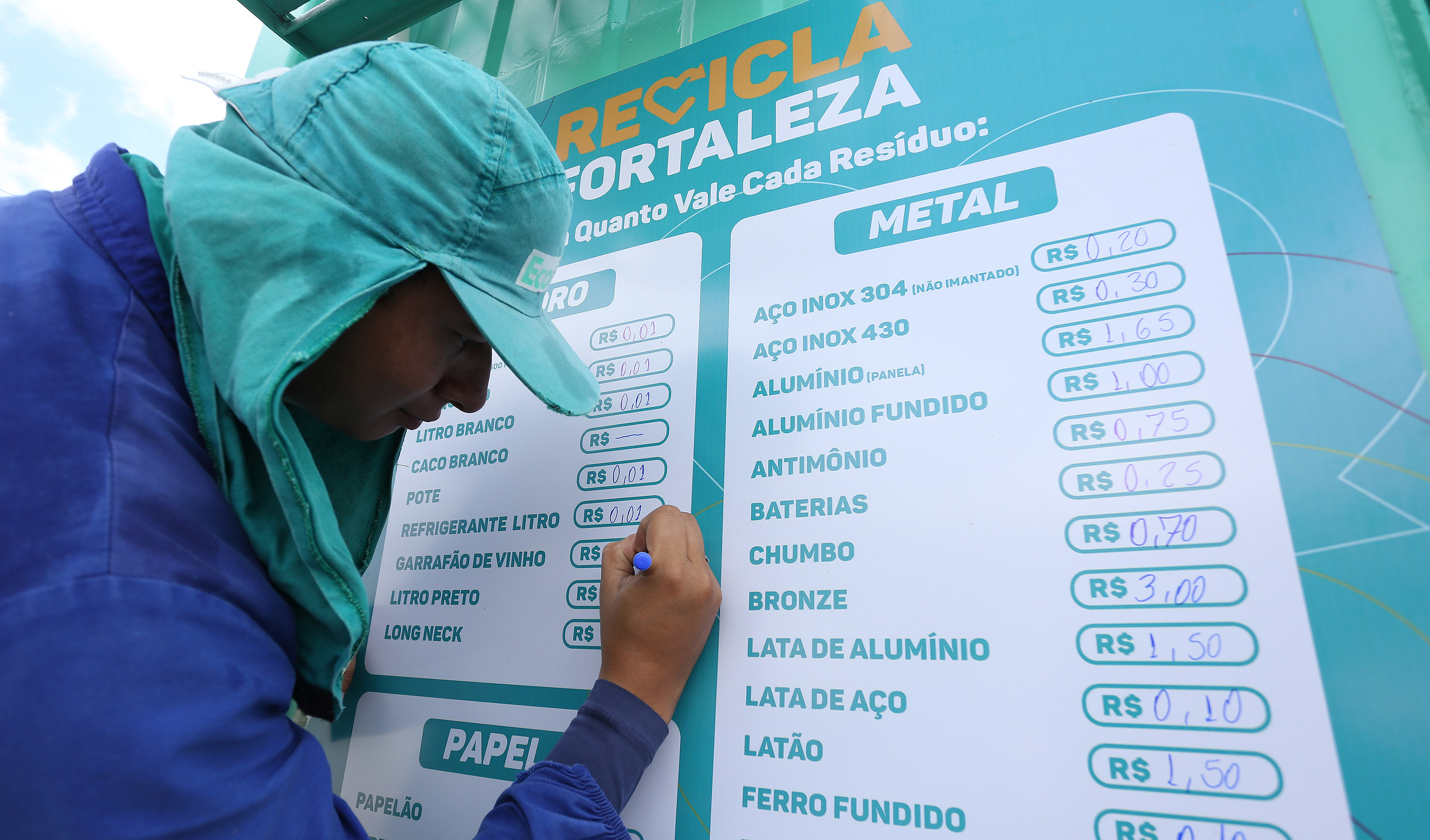 Homem escrevendo em tabela os valores dos resíduos