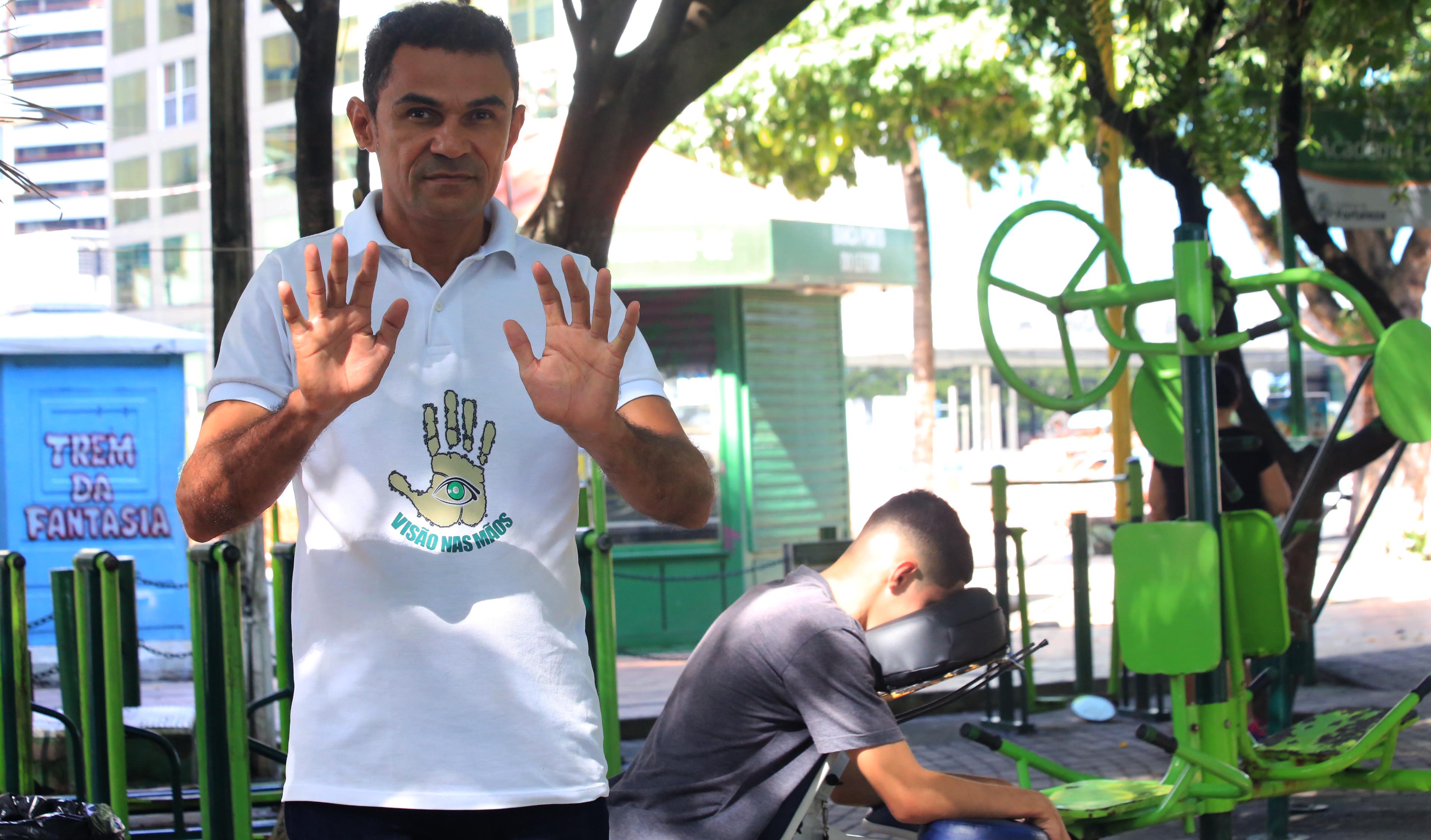 Homem mostra as mãos e veste camisa do projeto