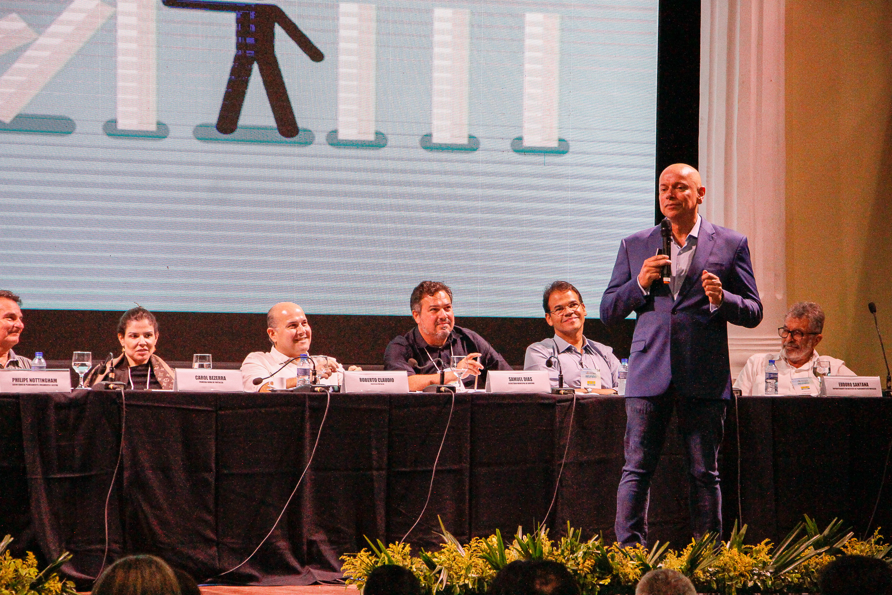 Leandro Karnal falando sobre o palco para o público sentado a frente