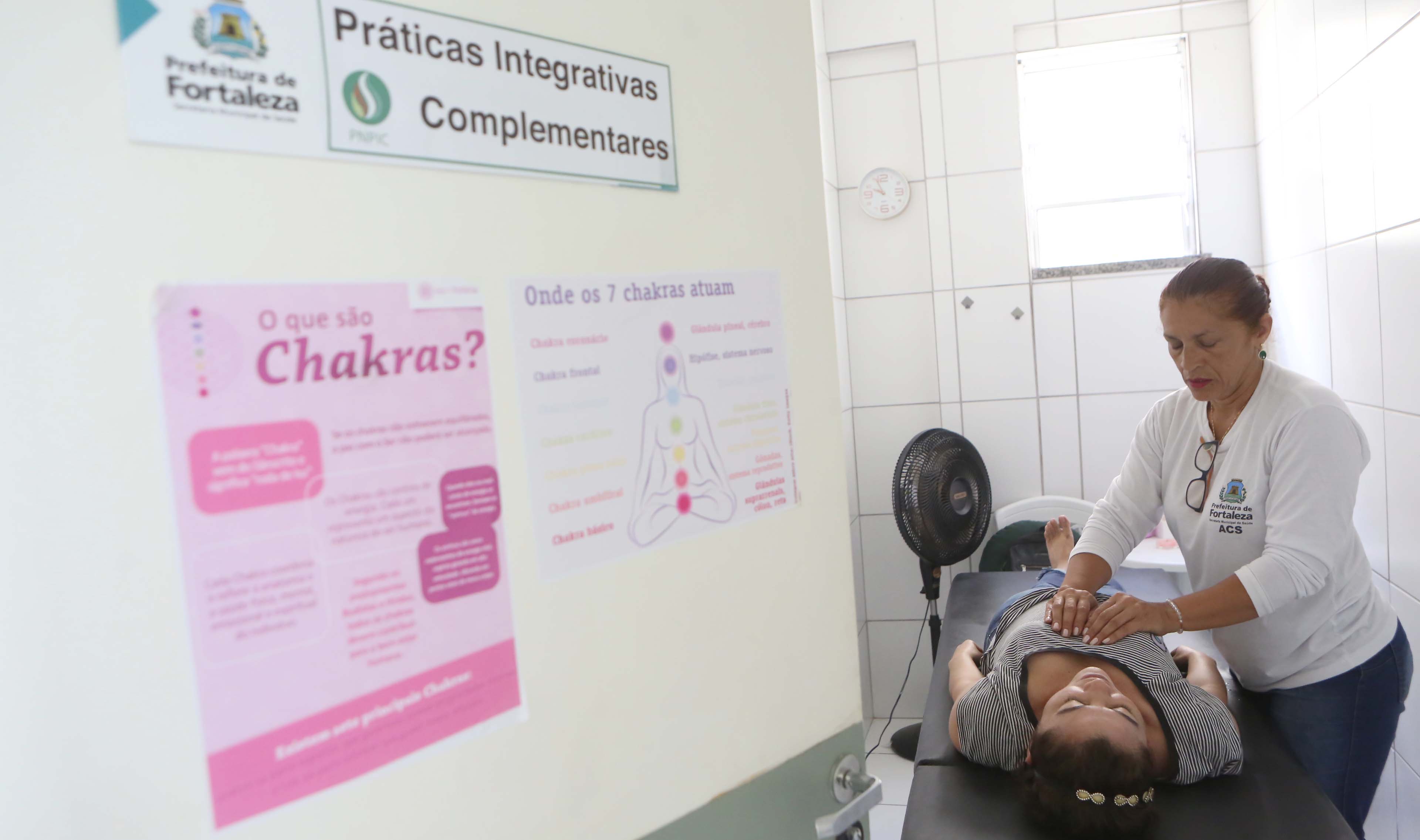 Mulher fazendo massagem em moça deitada na maca