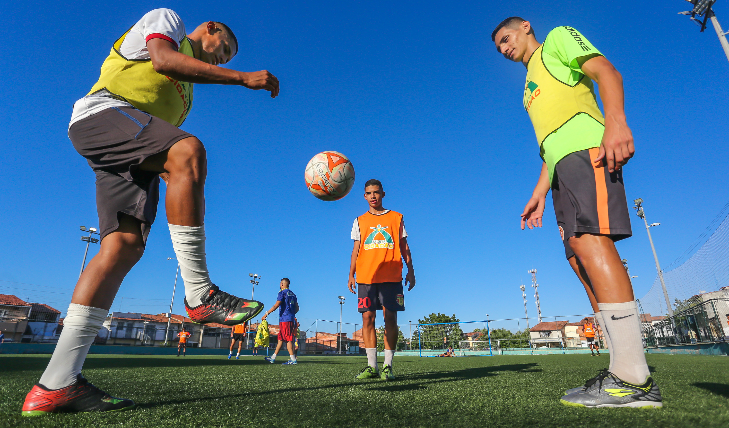 Três garotos jogando bola