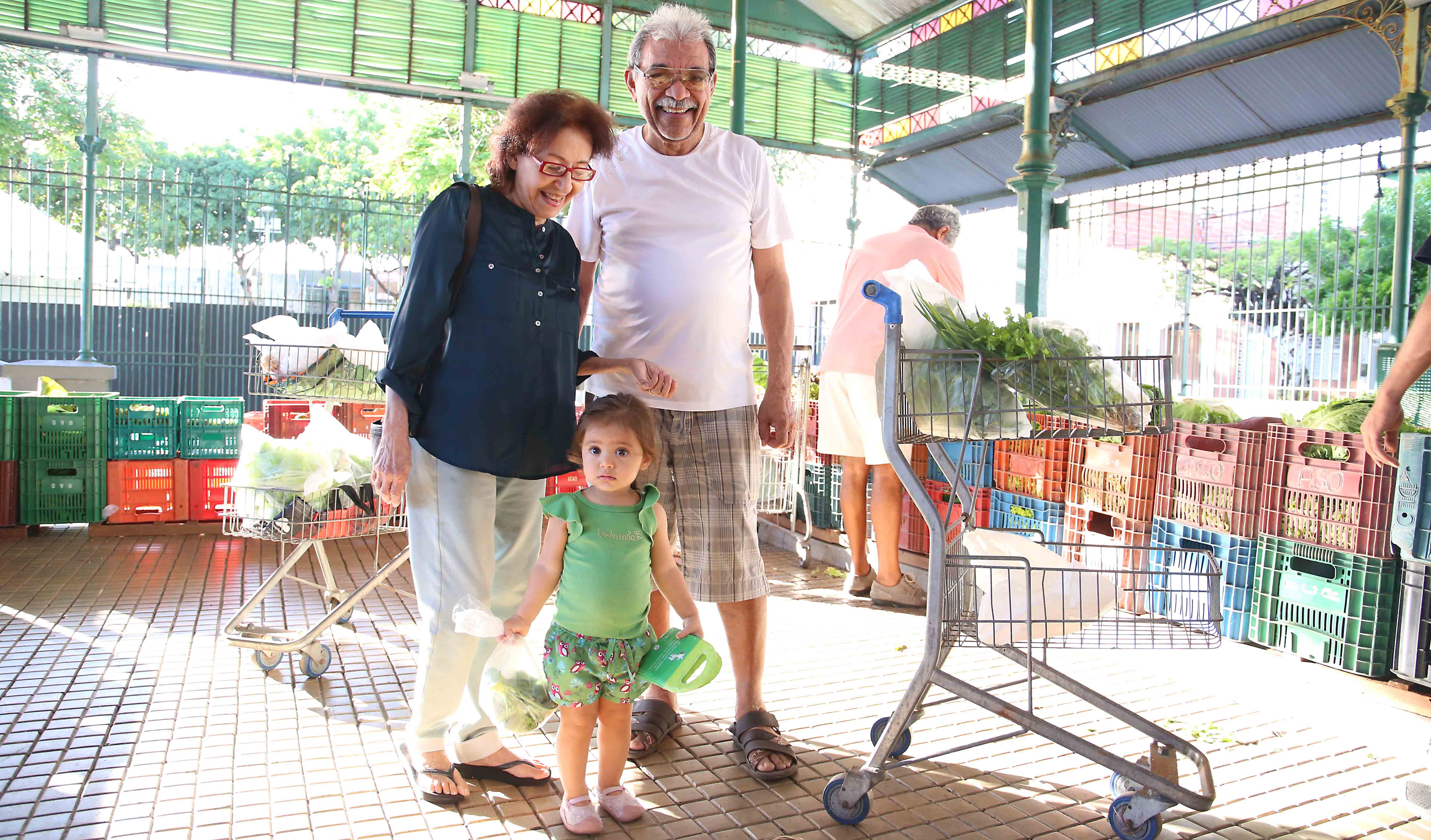 Senhora, senhor e garotinha em pé posando pra foto