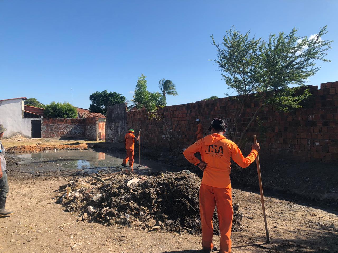 Operários junto monte de lixo em rua