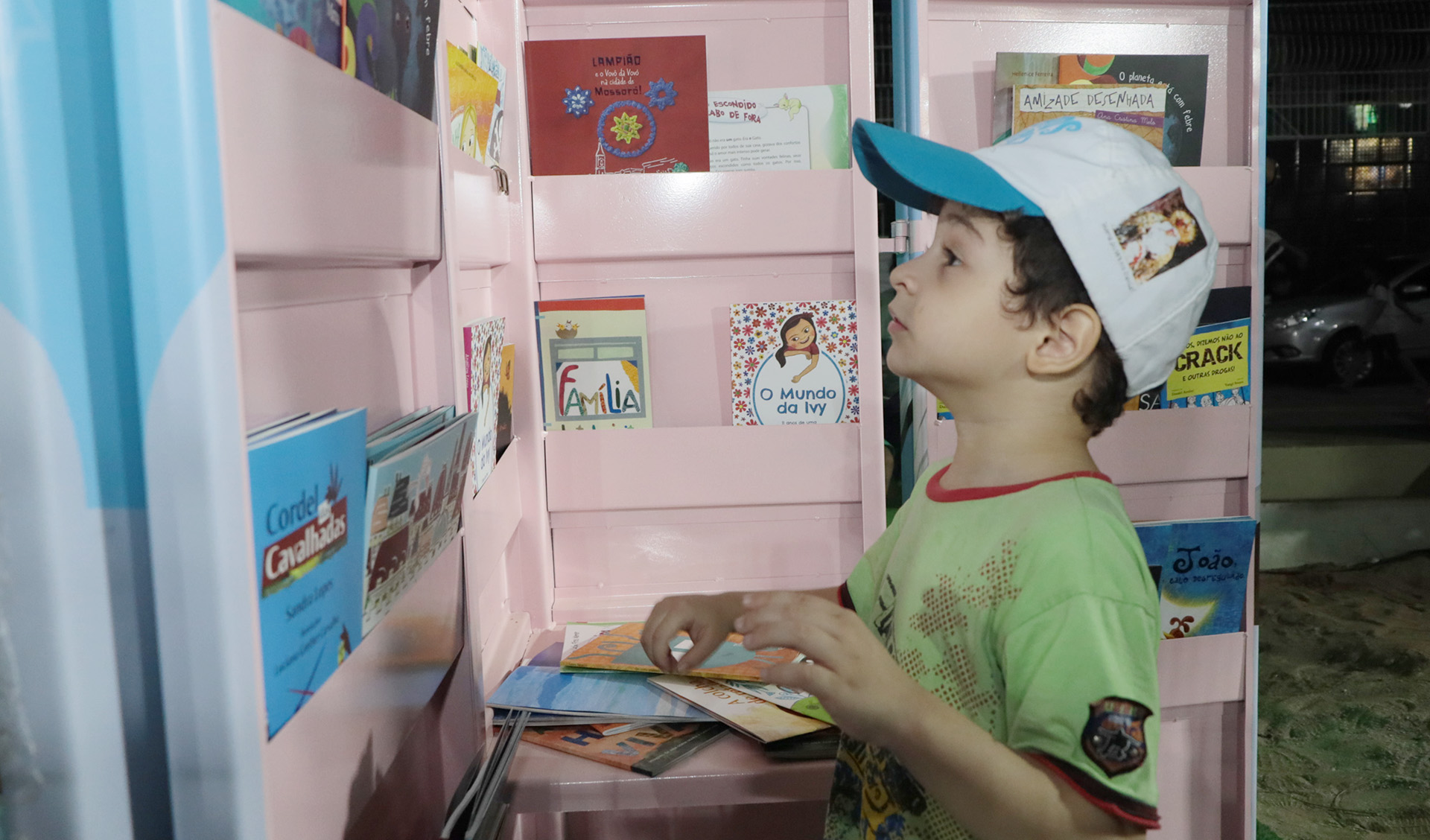 menino olha para uma prateleira de livros