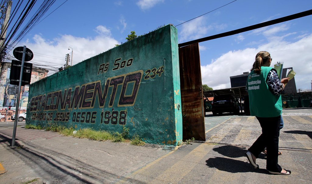 Fiscal entrando em estacionamento de carros para fiscalizar