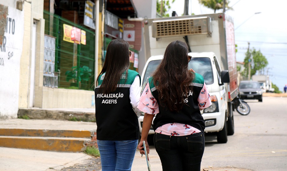 Fiscais caminhando ao lado de calçadas com degraus