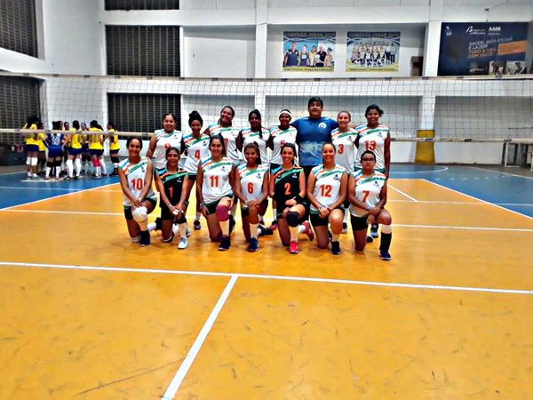 Jogadores de vôlei posam em quadra de esportes