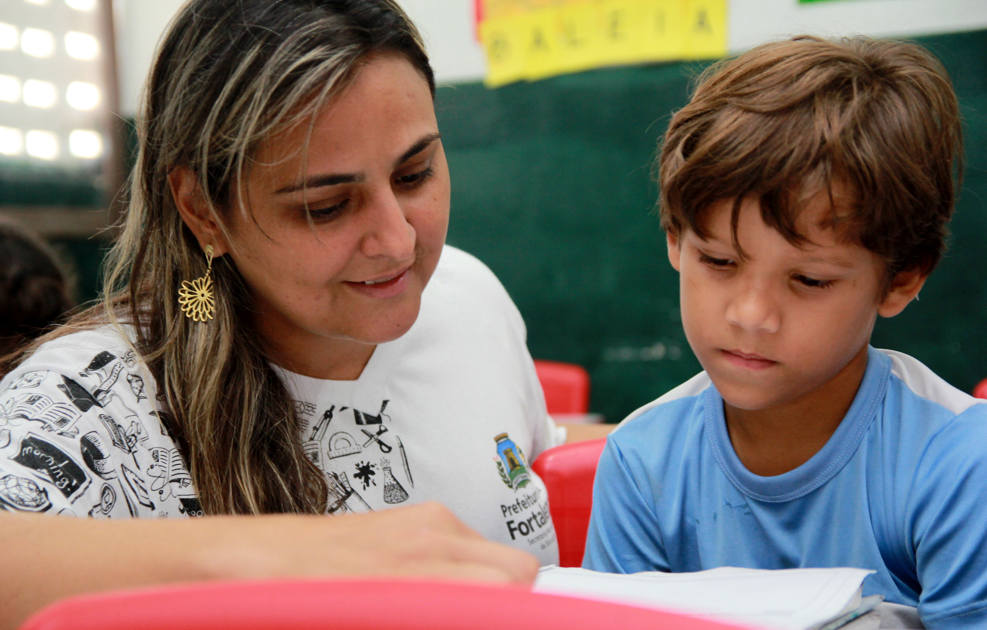 Professora em sala com aluno