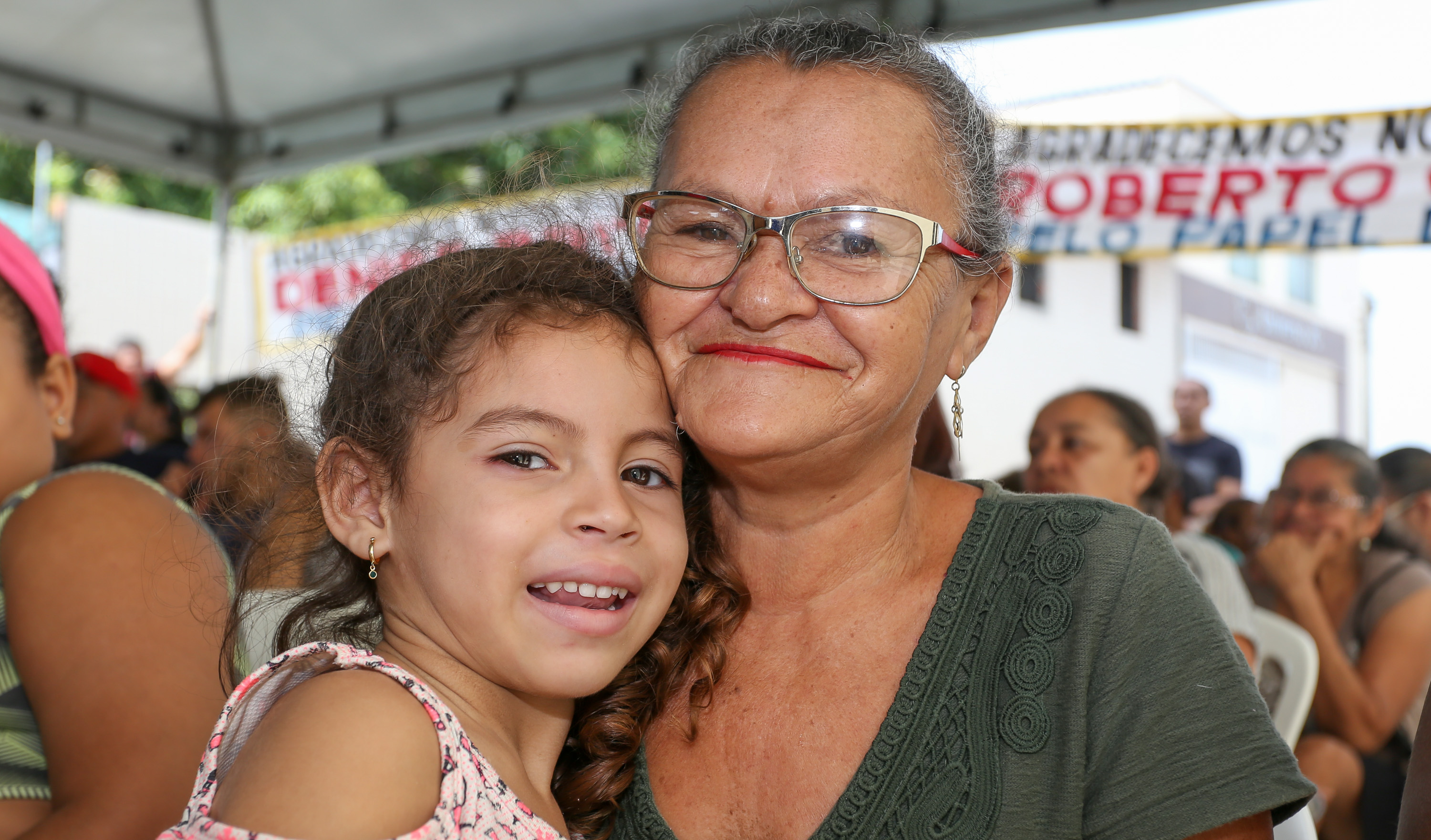 Senhora e criança abraçadas sorrindo para a foto