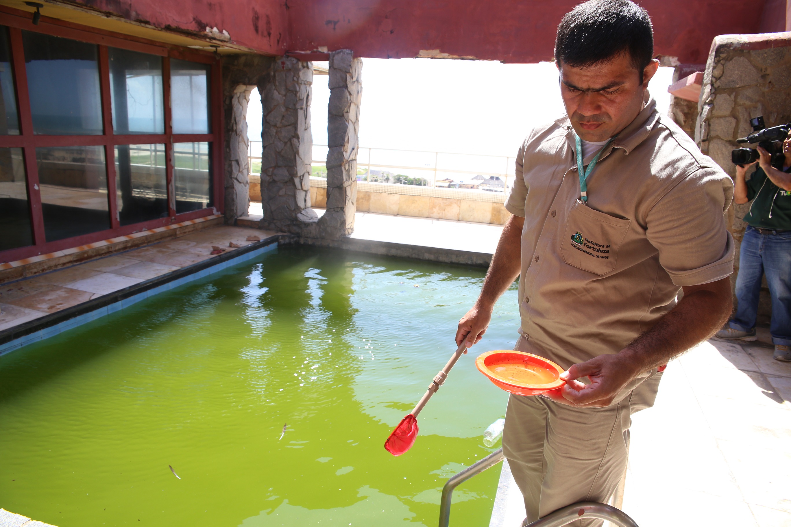 agente de saúde fiscalizando piscina