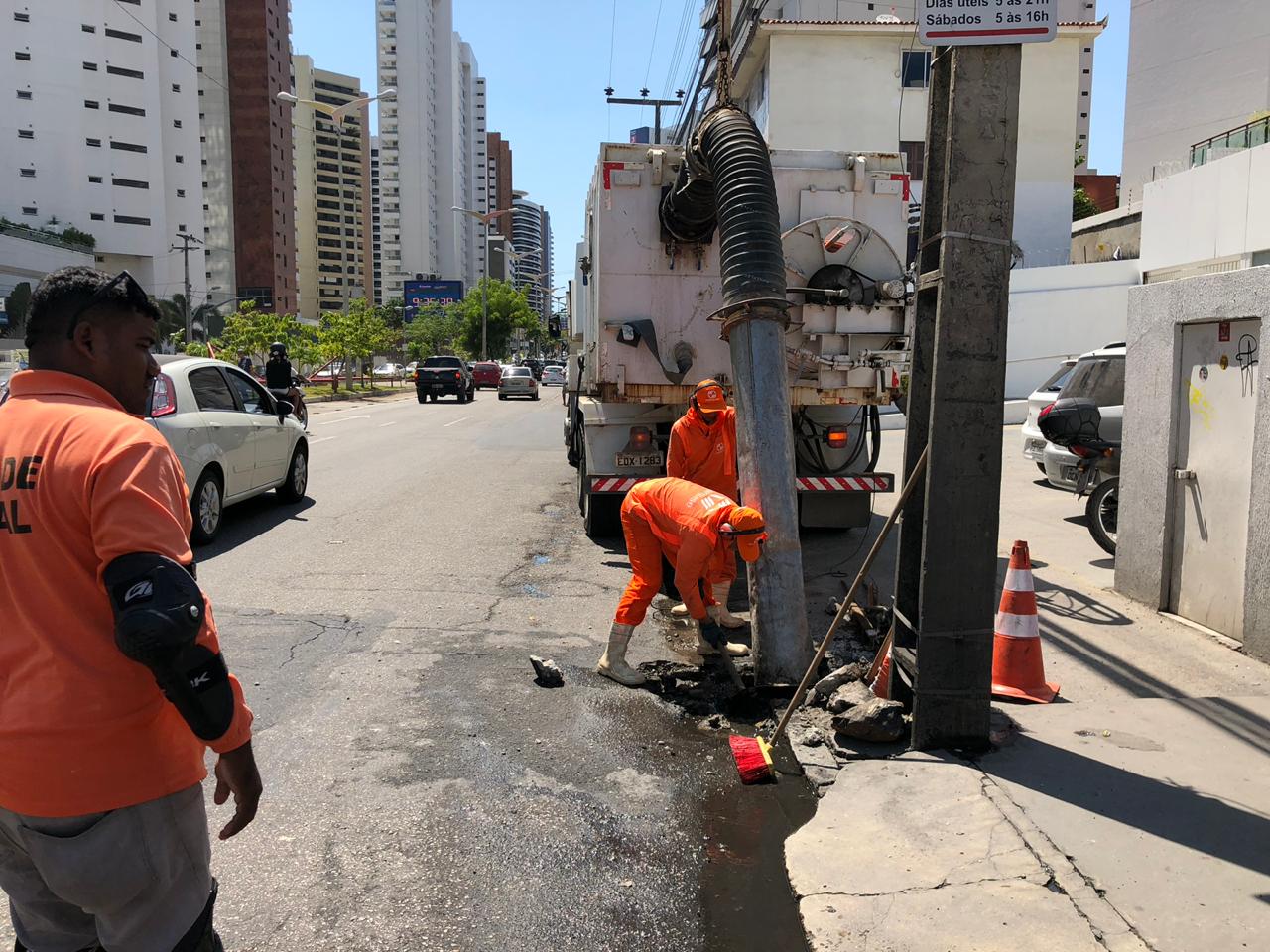 Homens trabalhando para desobstruir bocas de lobo e limpar as galerias pluviais.