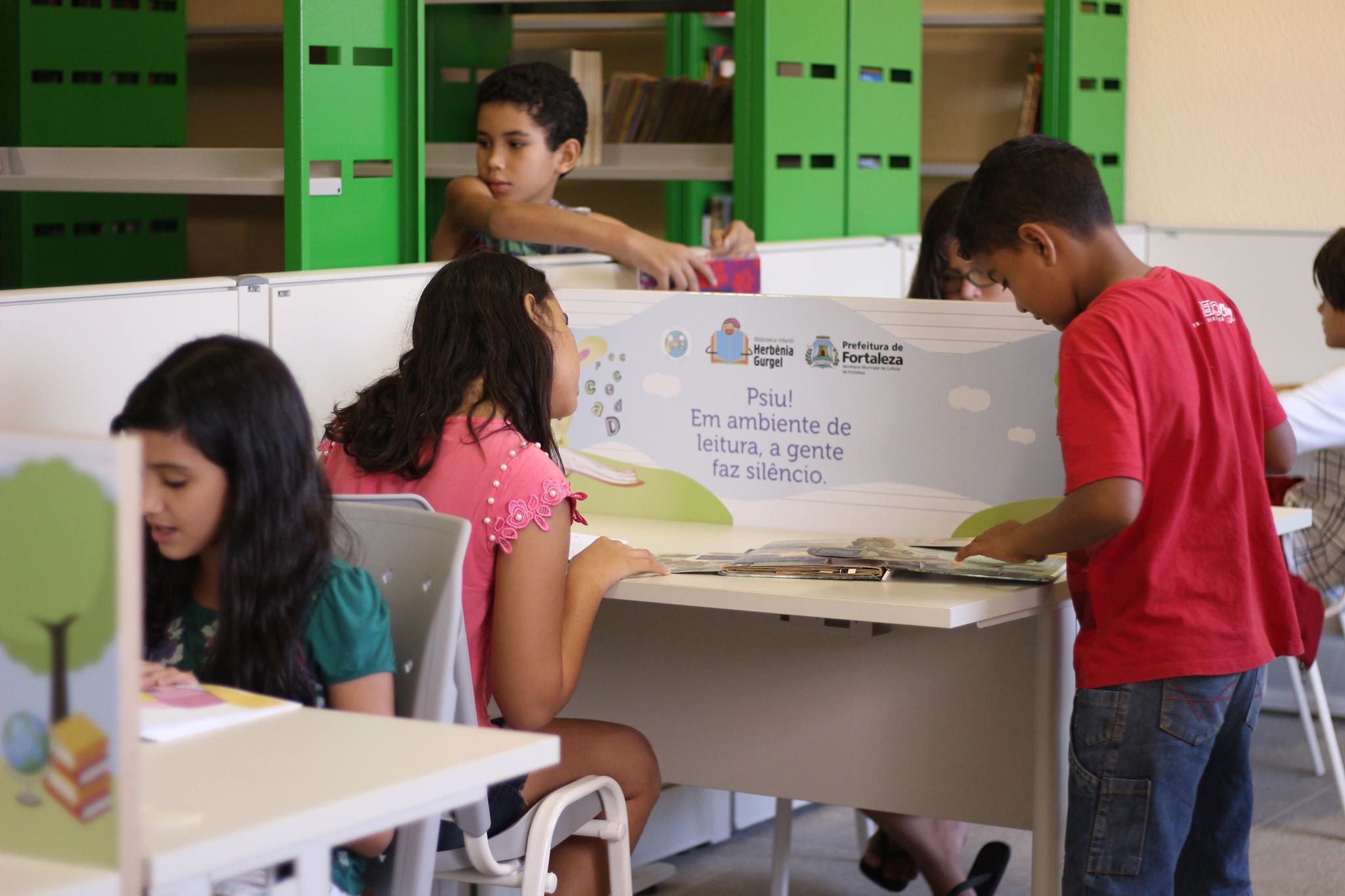 Crianças lendo livros na Biblioteca Infantil Herbênia Gurgel