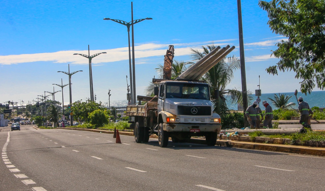 caminhão carregando postes na leste-oeste