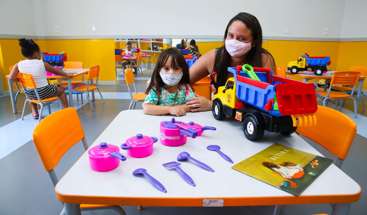 mãe e filha posam para a foto em uma sala do centro de educação infantil