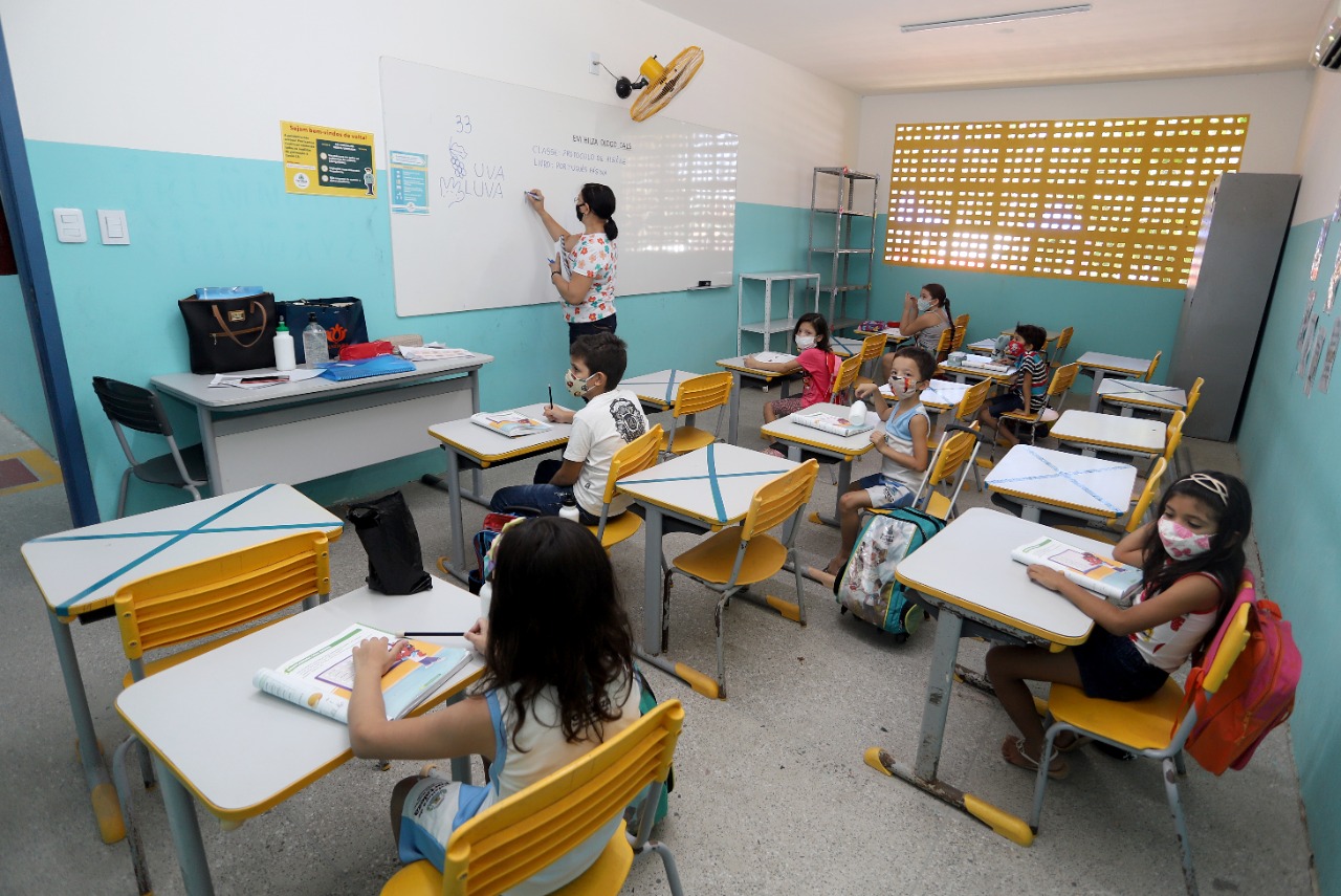 uma sala de aula com alunos e professora