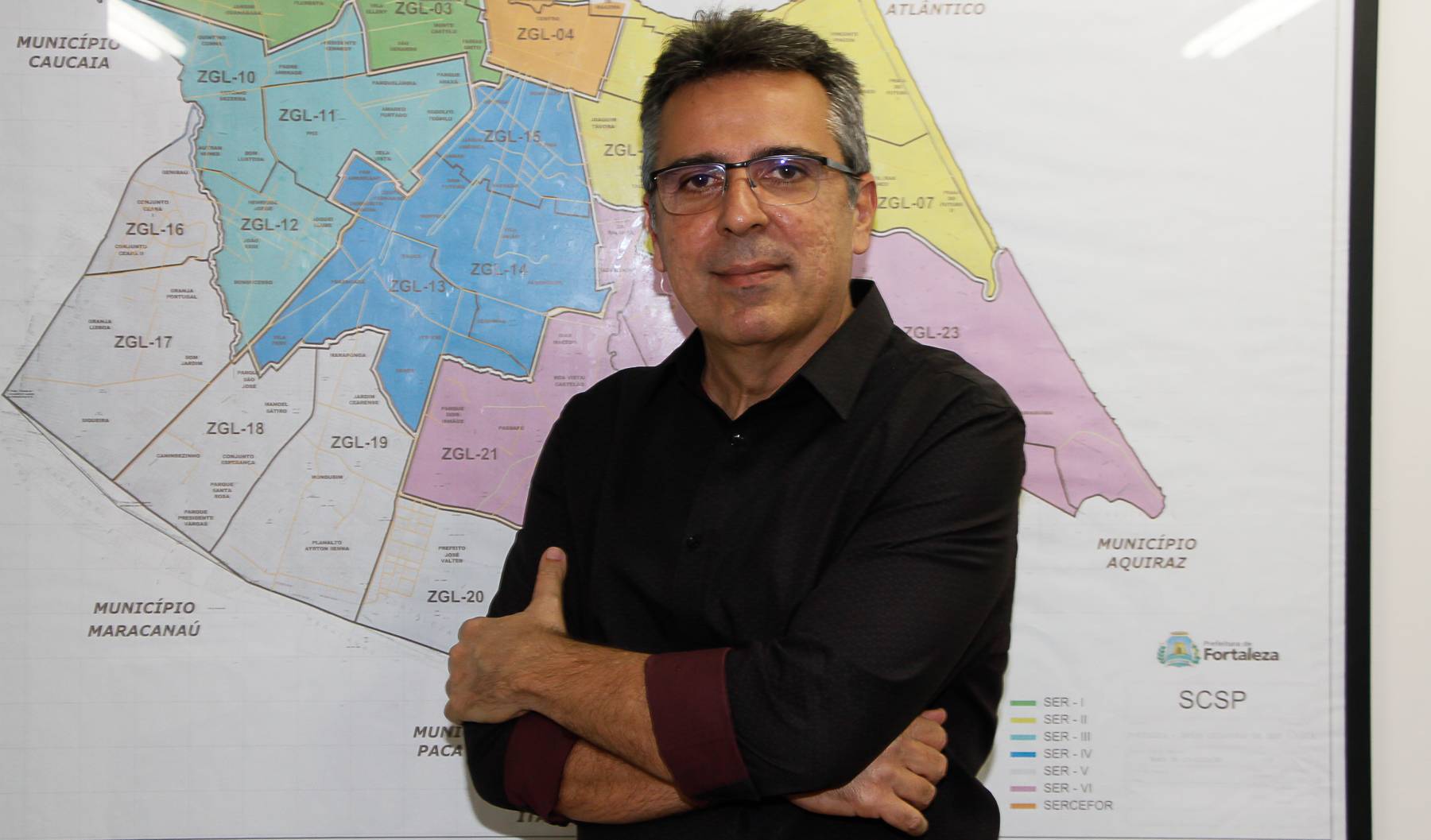 luiz alberto sabioi posa para a foto diante de um mapa de Fortaleza