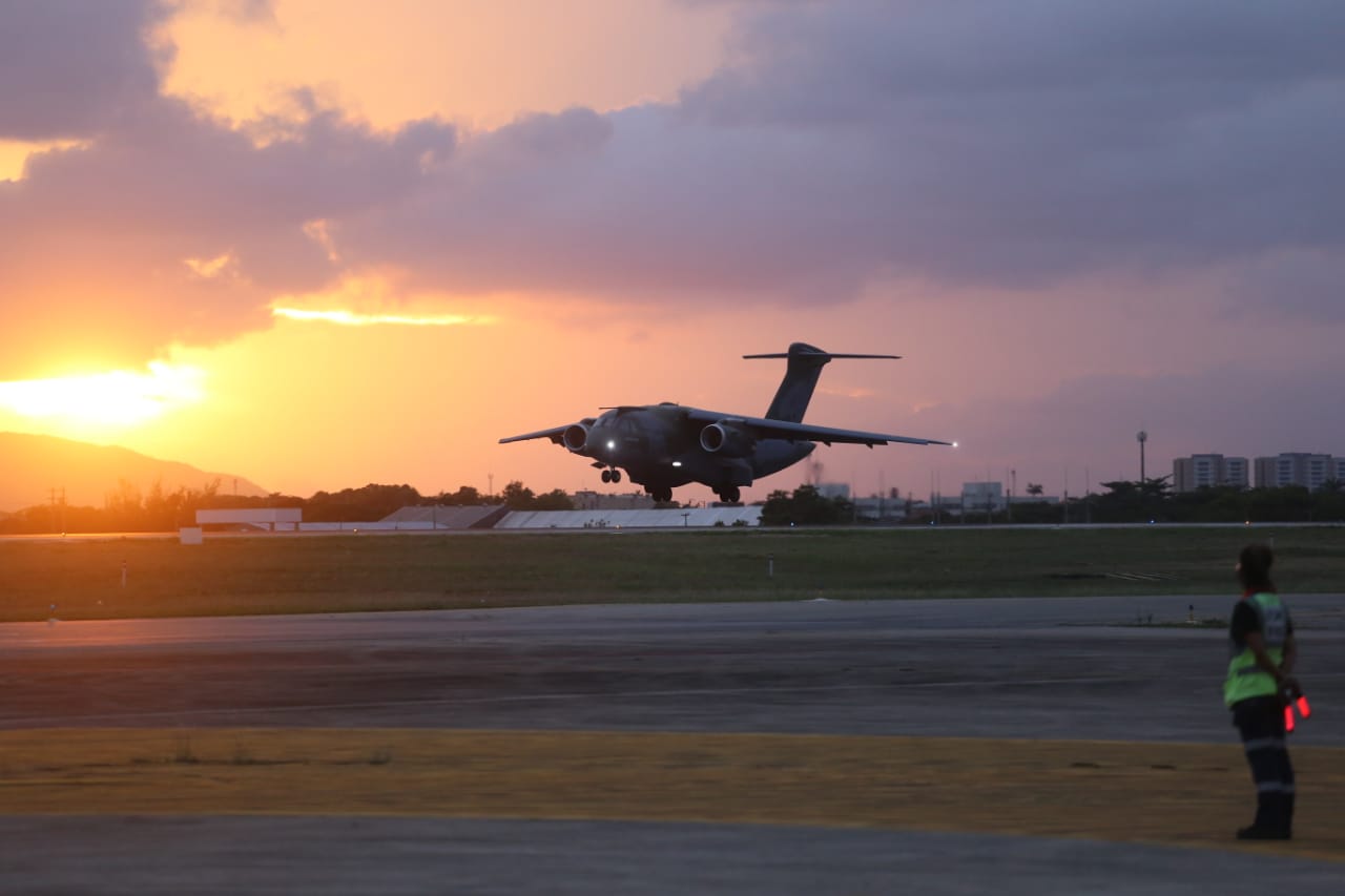 avião pousando com pôr do sol ao fundo