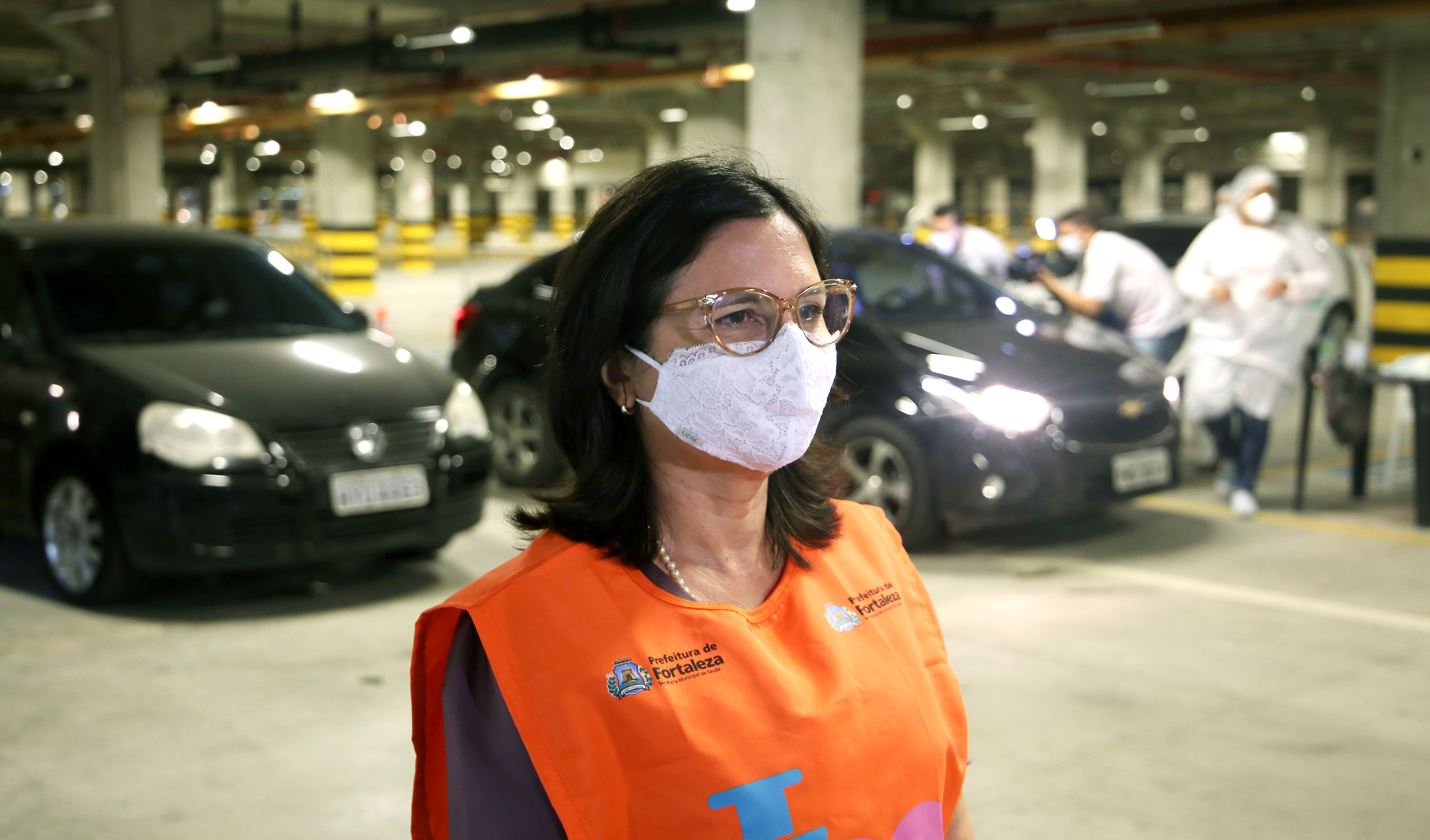 secretária ana estela de máscara dentro do estacionamento do centro de eventos