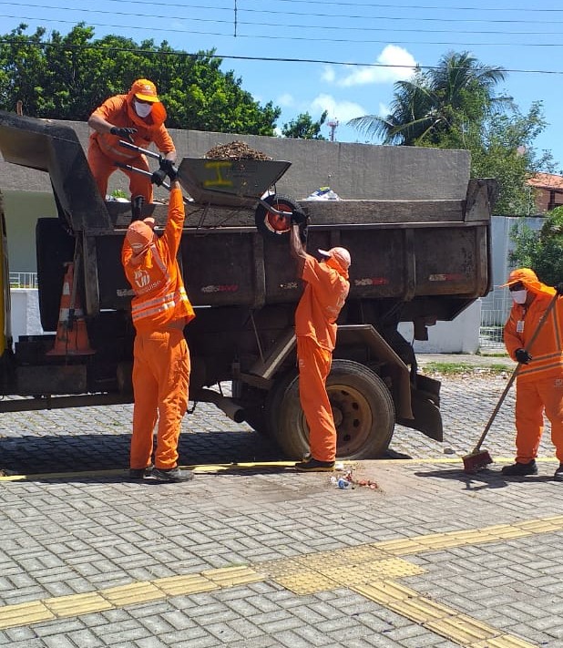 garis recolhendo entulhos e colocando em caminhão