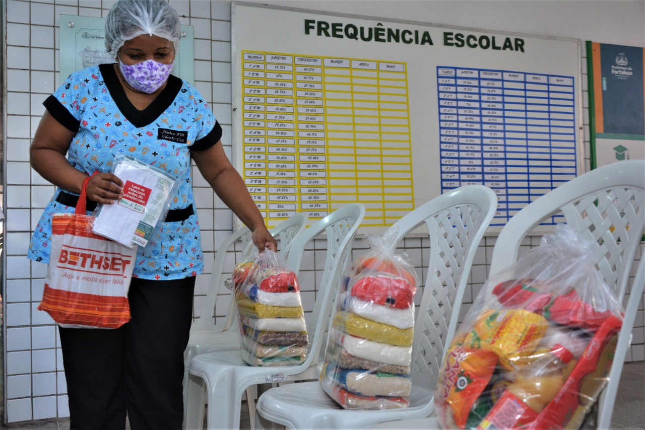 mulher com máscara pega uma cesta báscia