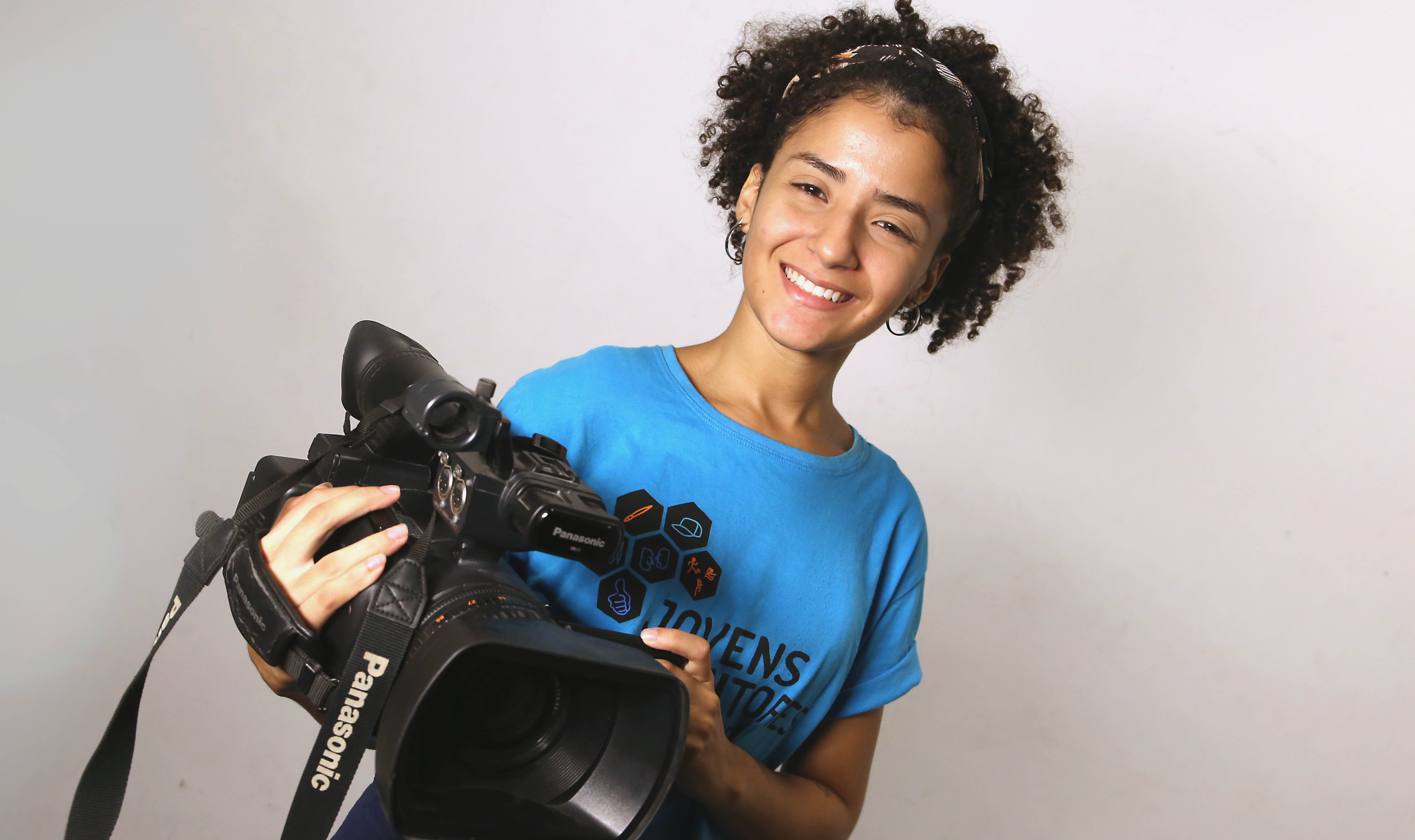 garota sorrindo para a foto e segurando uma filmadora