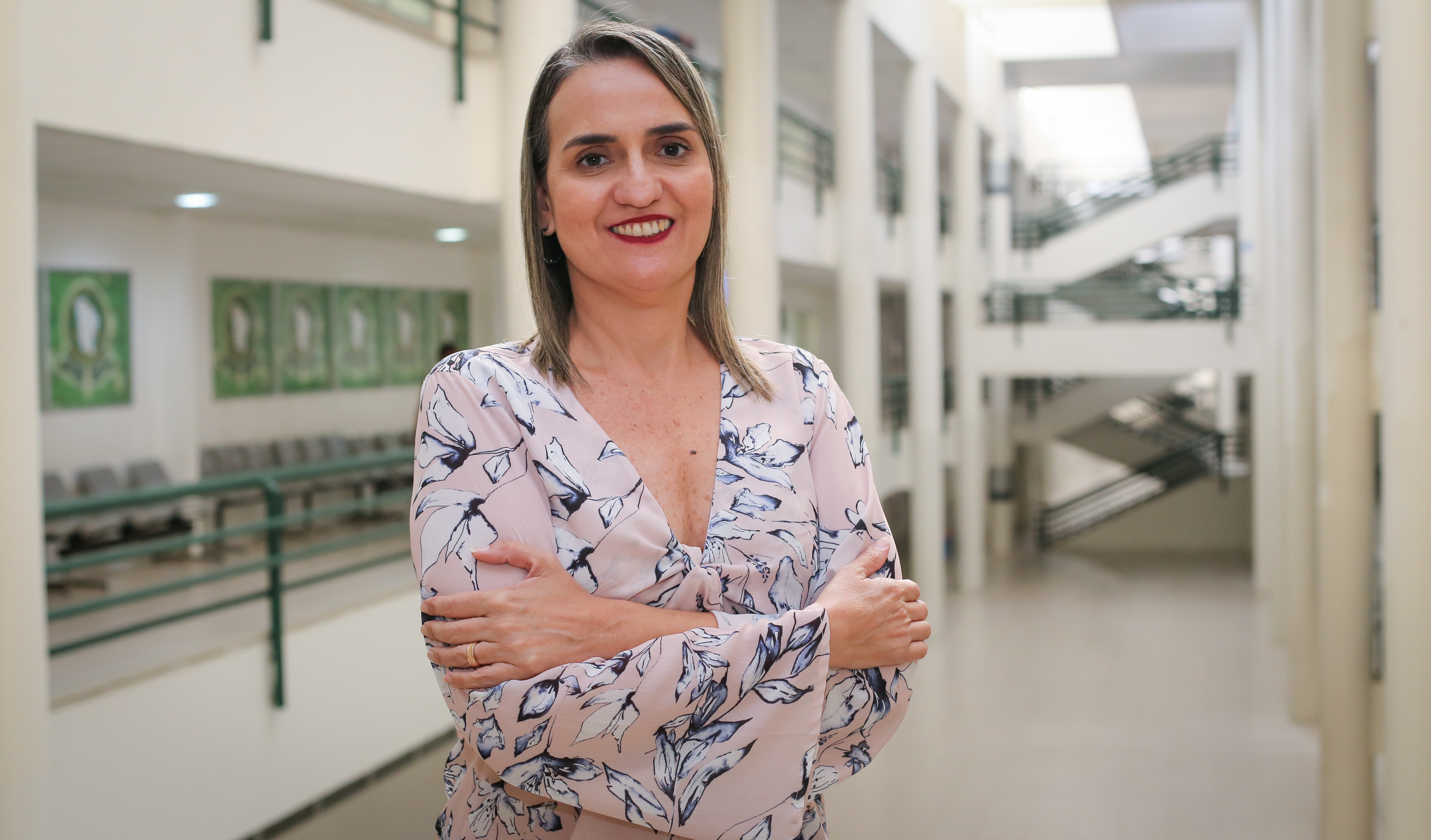 mulher posando para a foto e sorrindo com braços cruzados