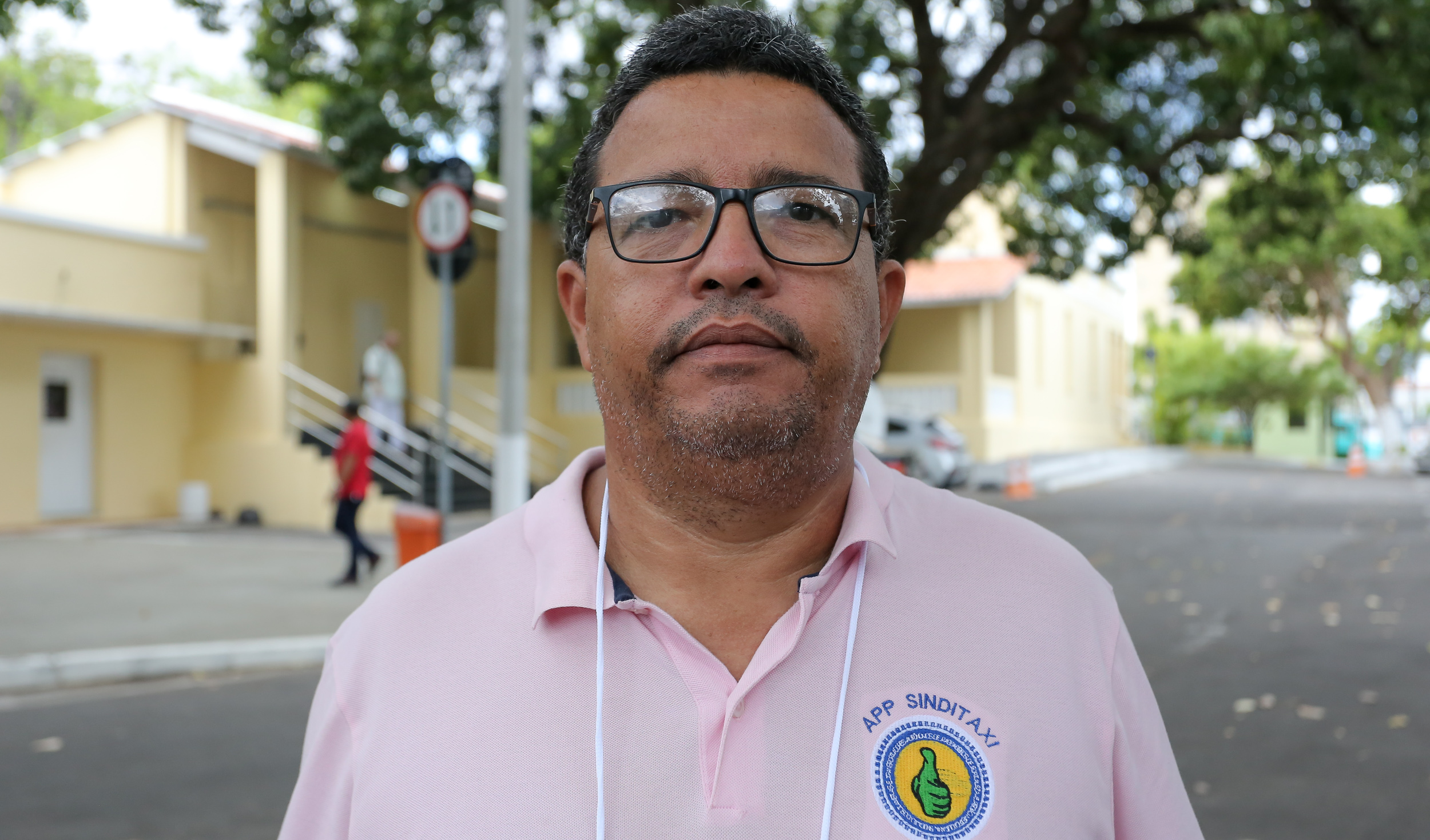 homem de óculos posando para a foto