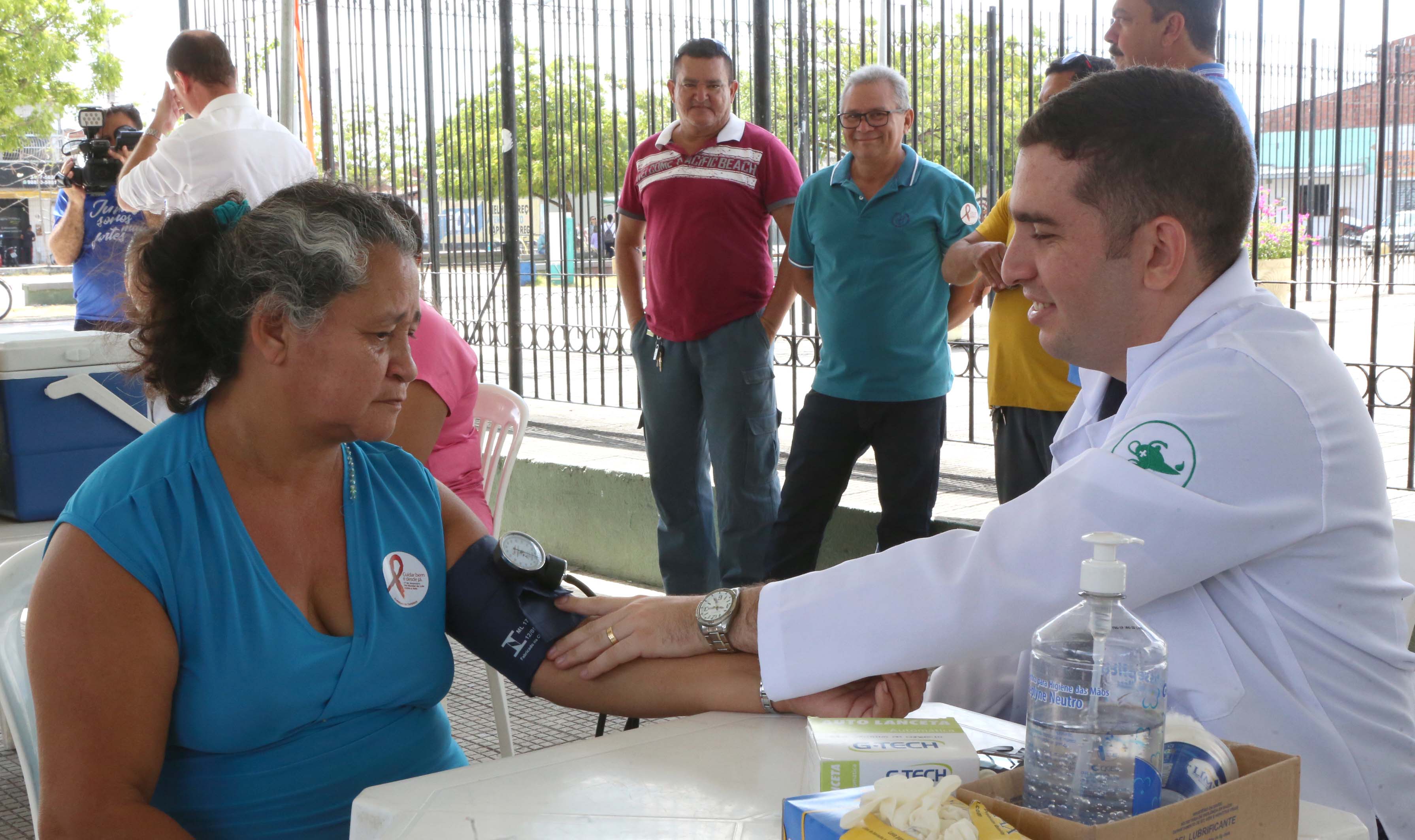 rapaz de jaleco branco afrindo pressão arterial de senhora