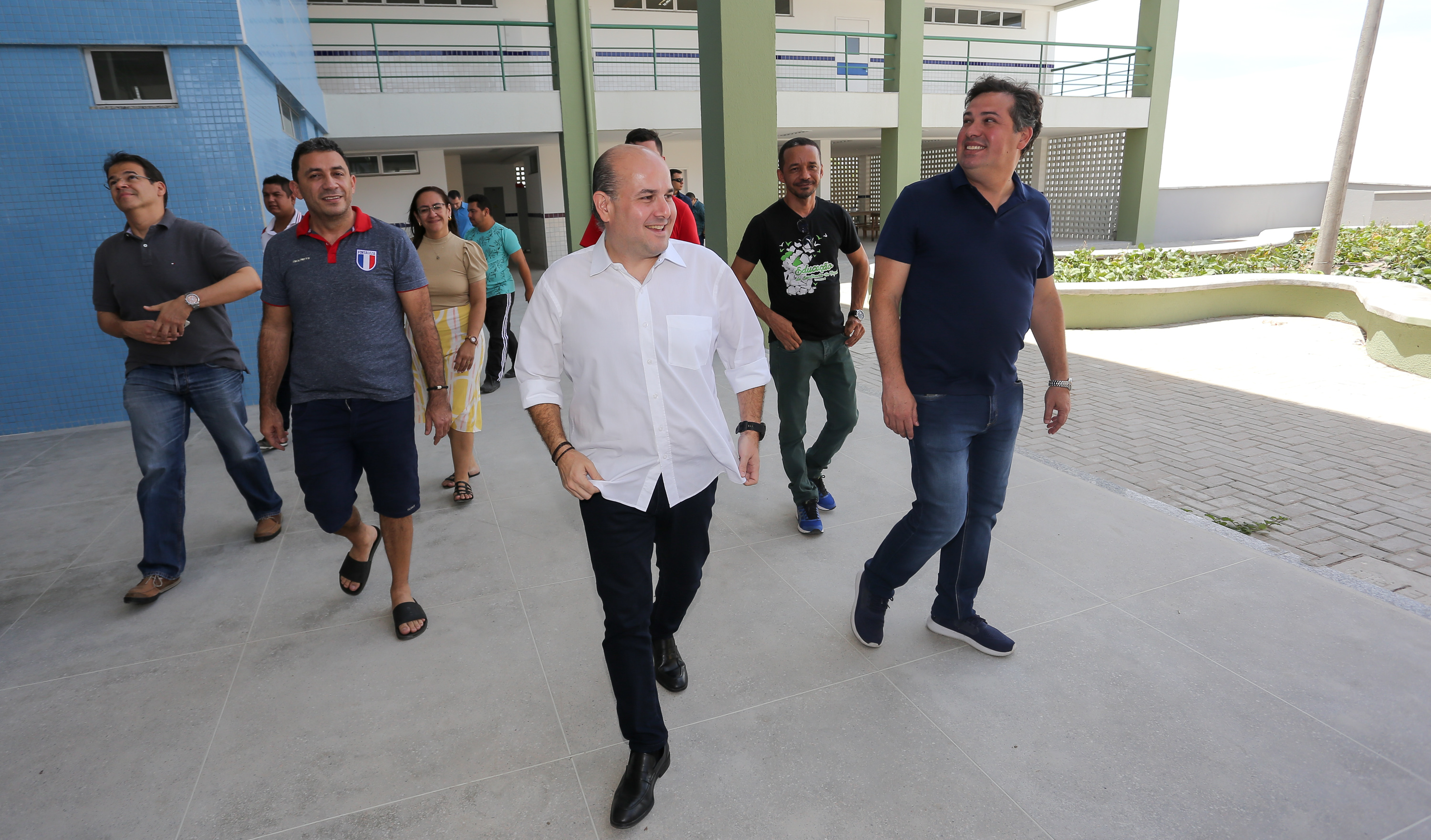 prefeito caminhando por escola ao lado de pessoas