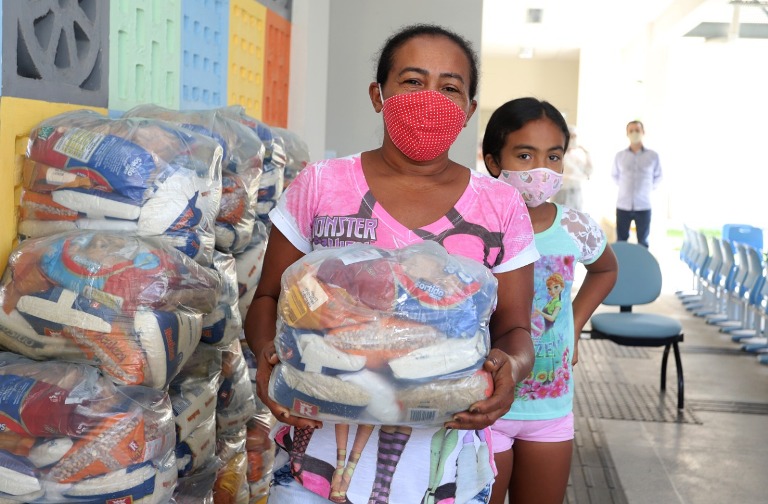 Imagem de uma mãe de aluno com kit de alimentação