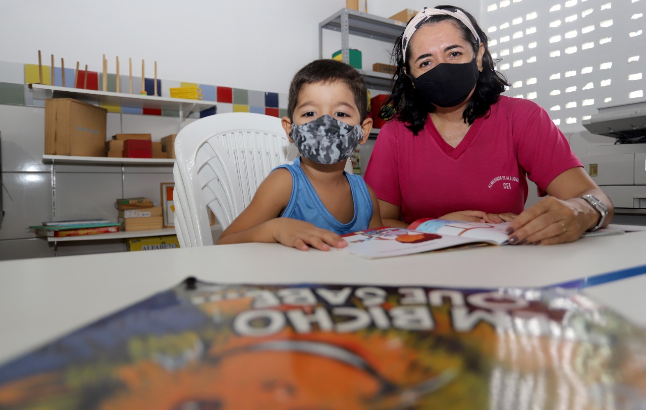 Aluna e professora durante atividade em sala de aula