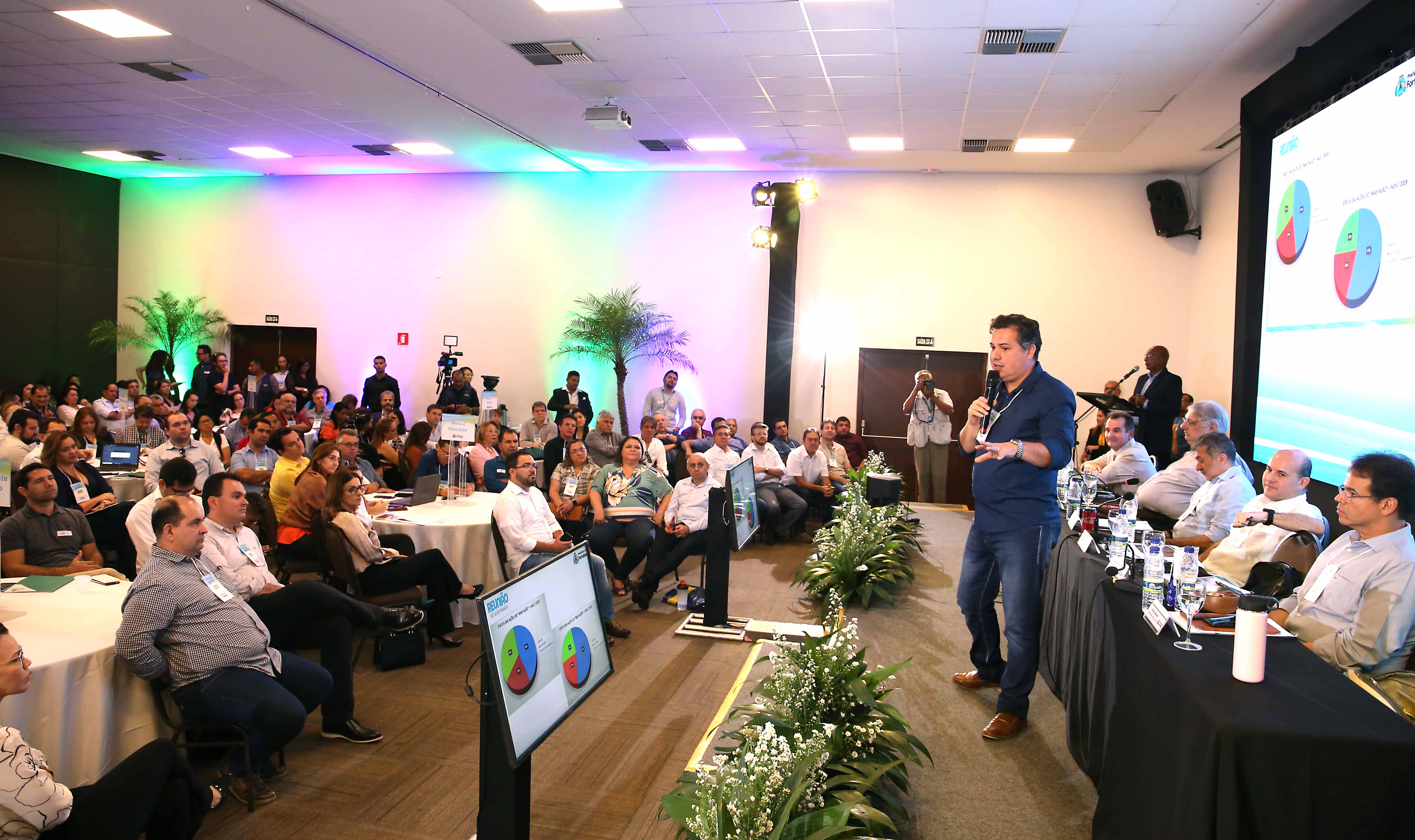 samuel dias em cima de palco de perfil falando com plateia