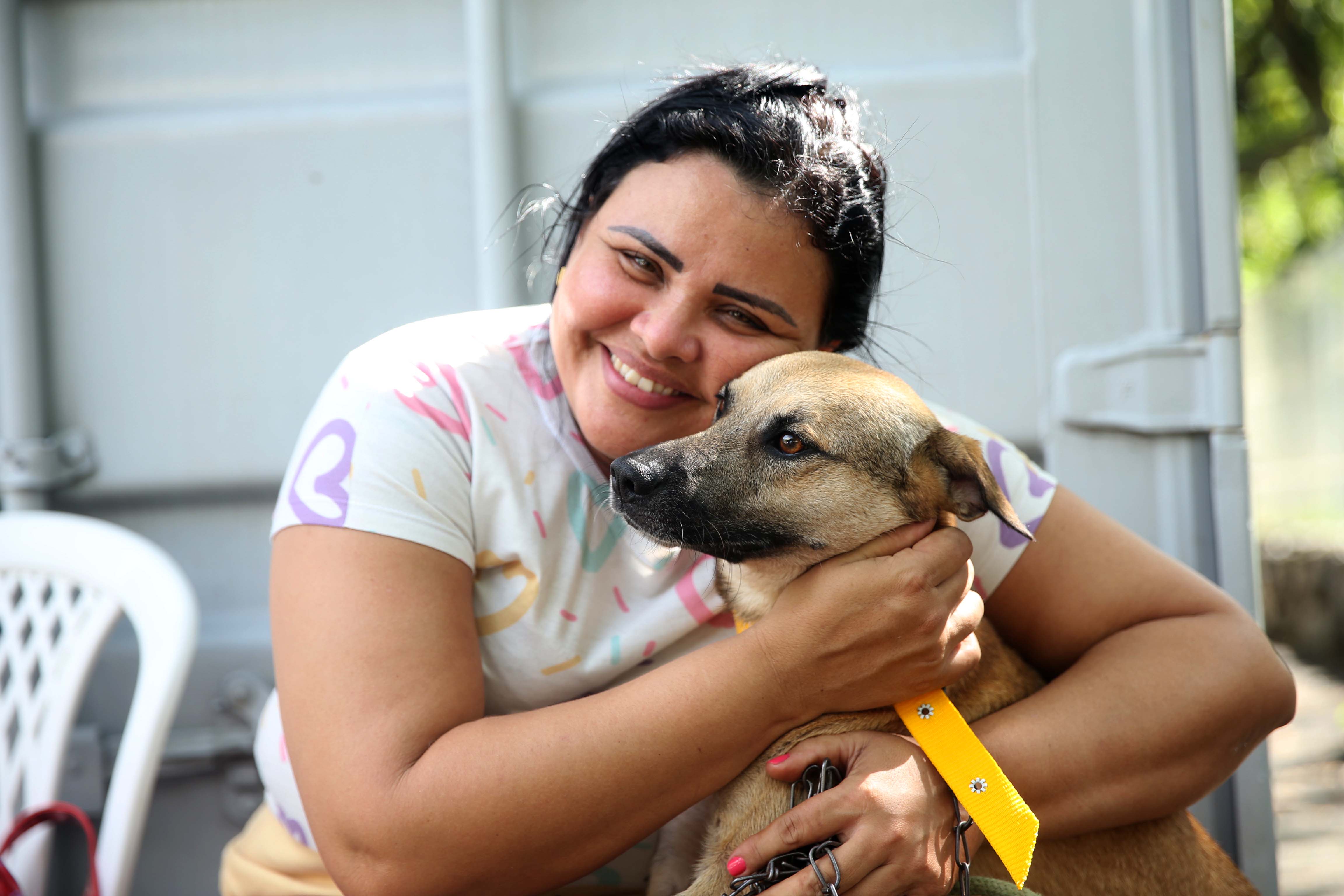 Tutora abraça cachorro.