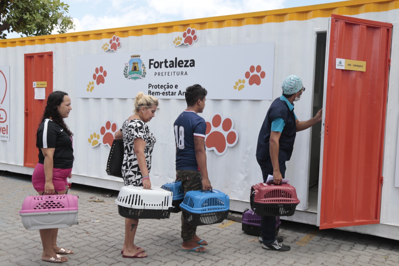 Pessoas aguardam próximas a contêiner do VetMóvel. 