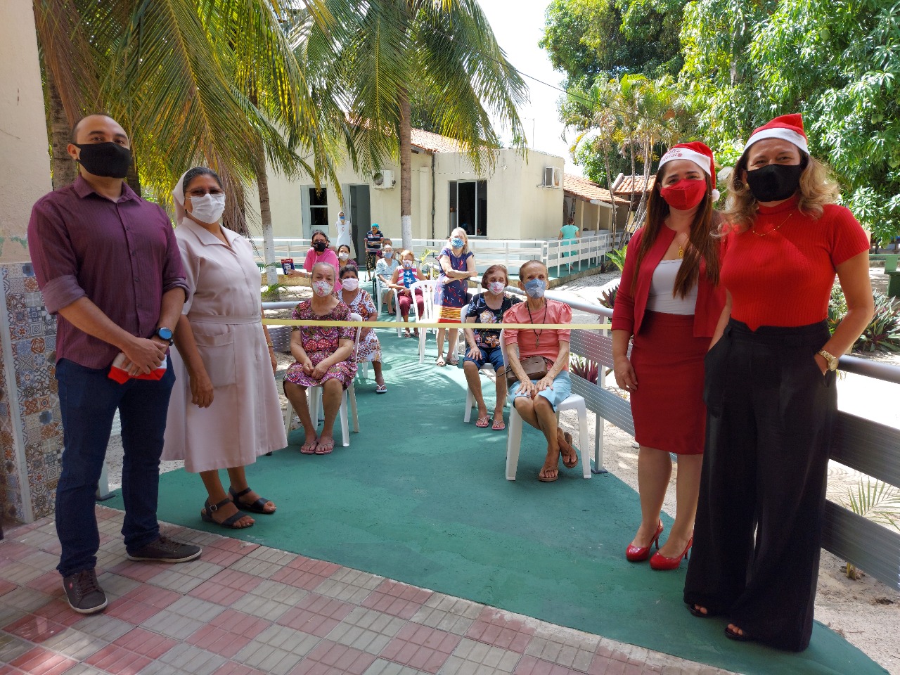 Representantes da  Sesec e da GMF entregando os presentes e as doações para as senhoras da Casa de Nazeré