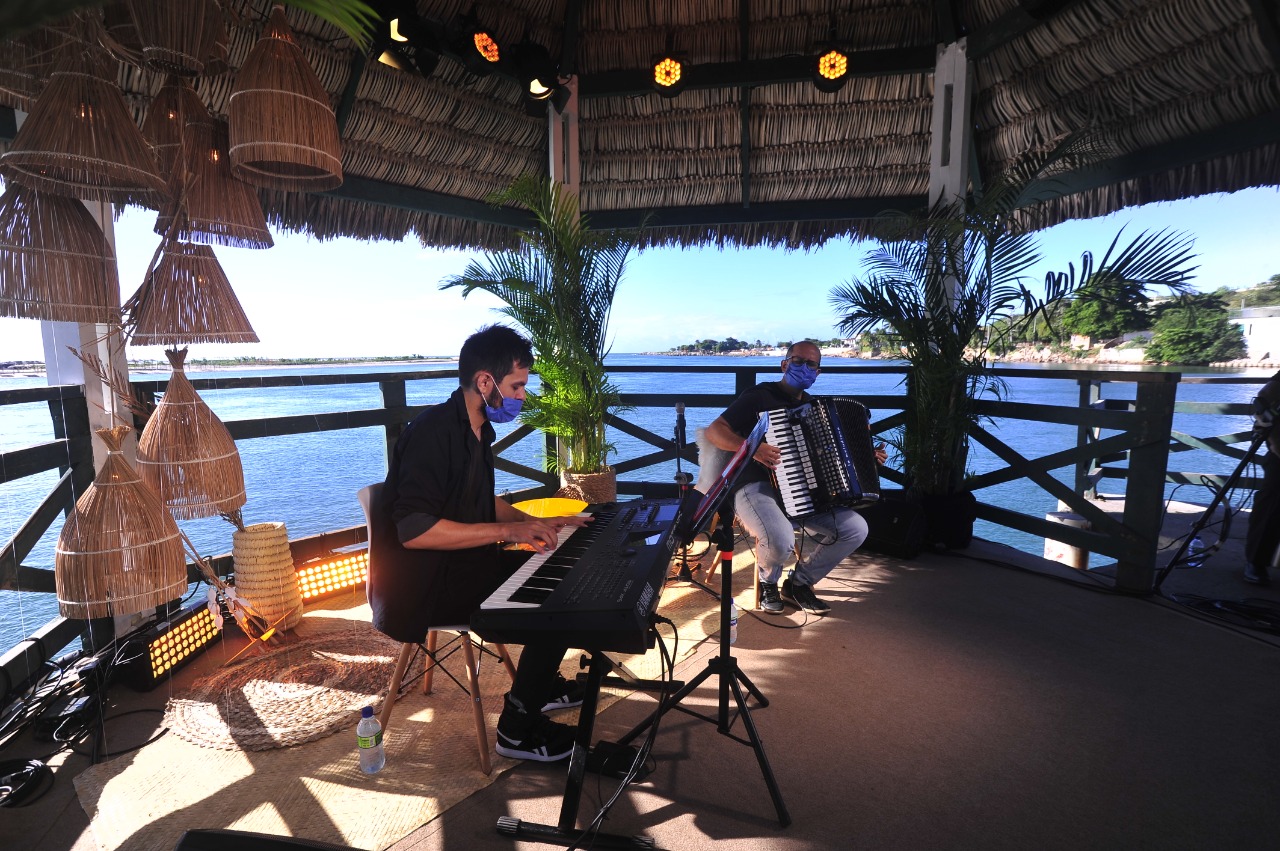 dois músicos do grupo Brazilian Duo realizam apresentação musical no píer da Barra do Ceará