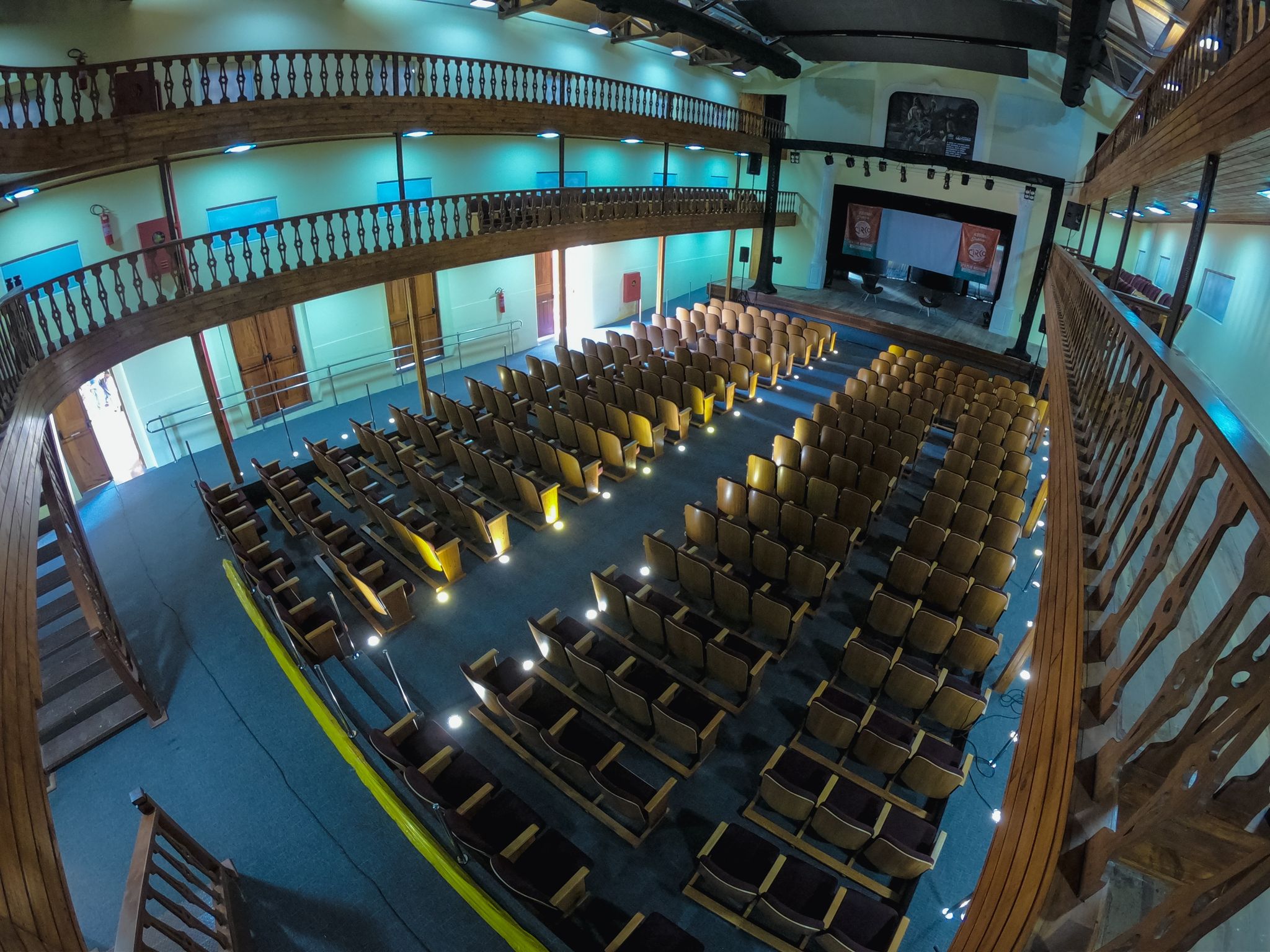 foto panorâmica do espaço interno do Teatro São José, sem público, apenas com cadeiras e palco.