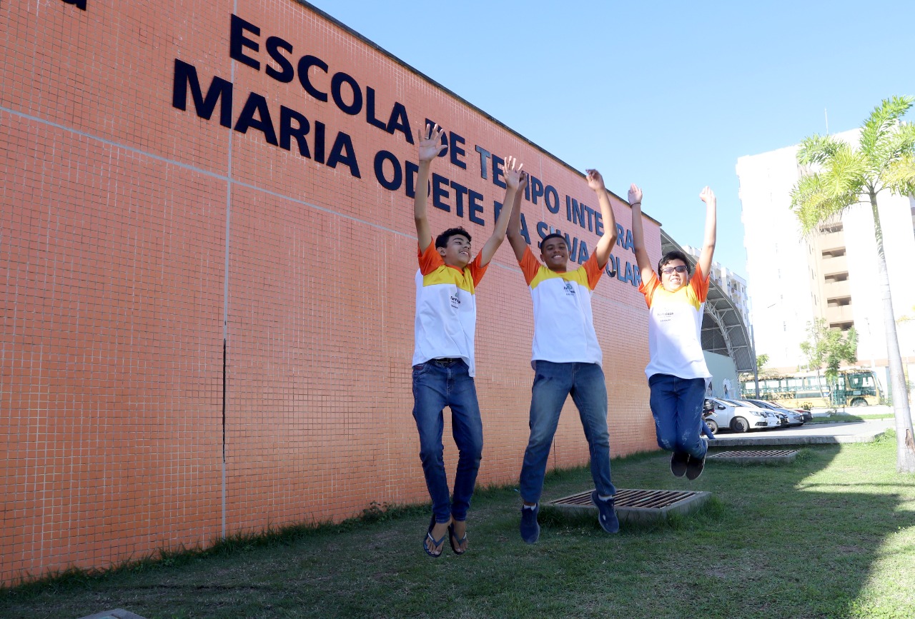 Alunos pulando na frente de uma ETI