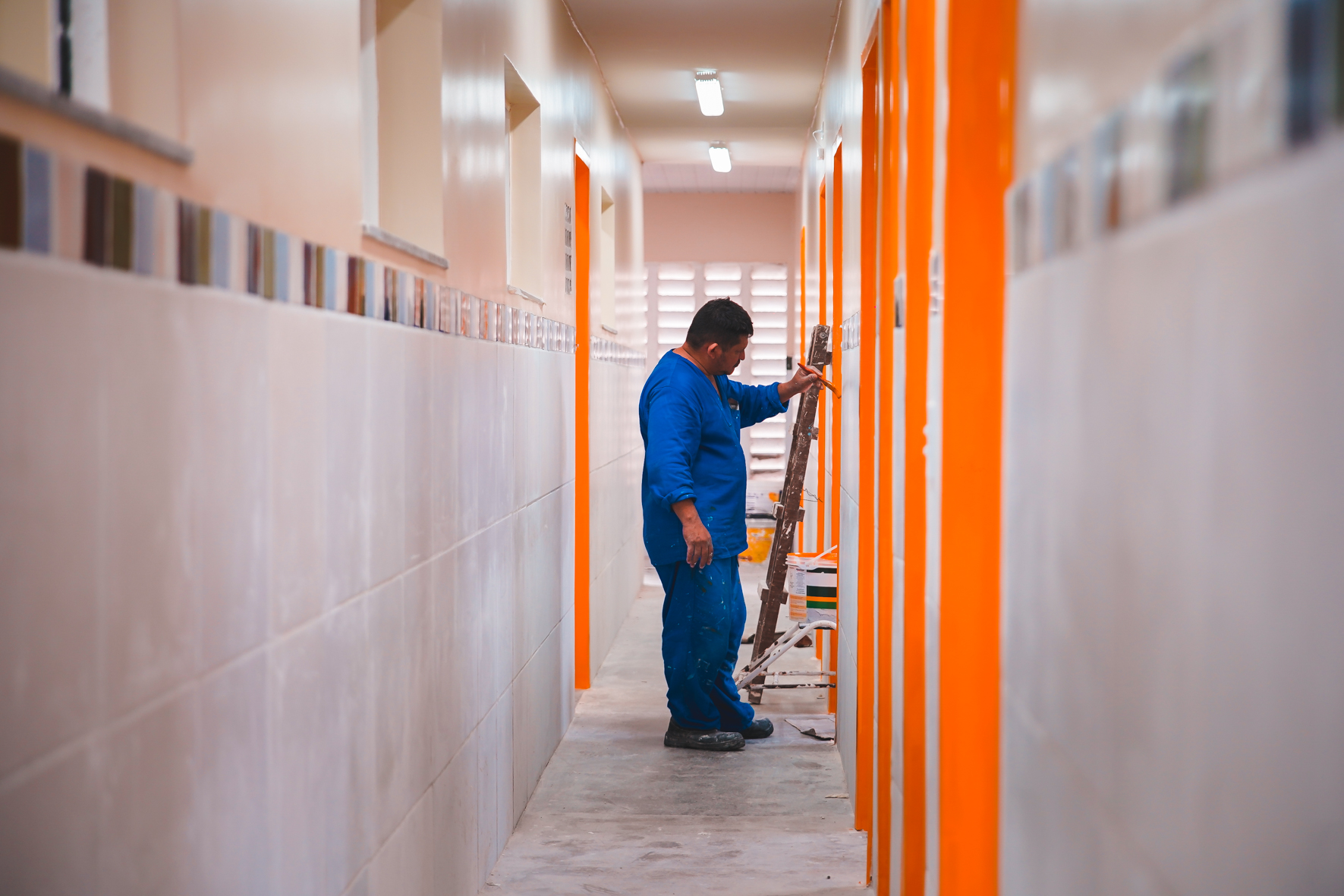 operário pintando o corredor de um posto de saúde