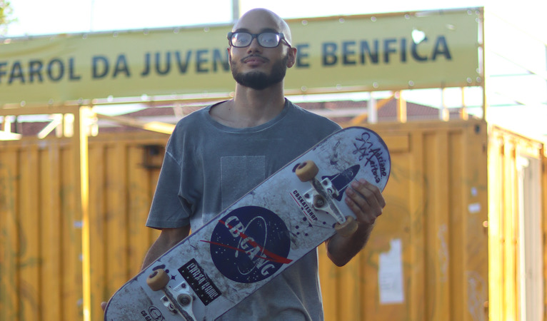 jovem posa para a foto segurando um skate