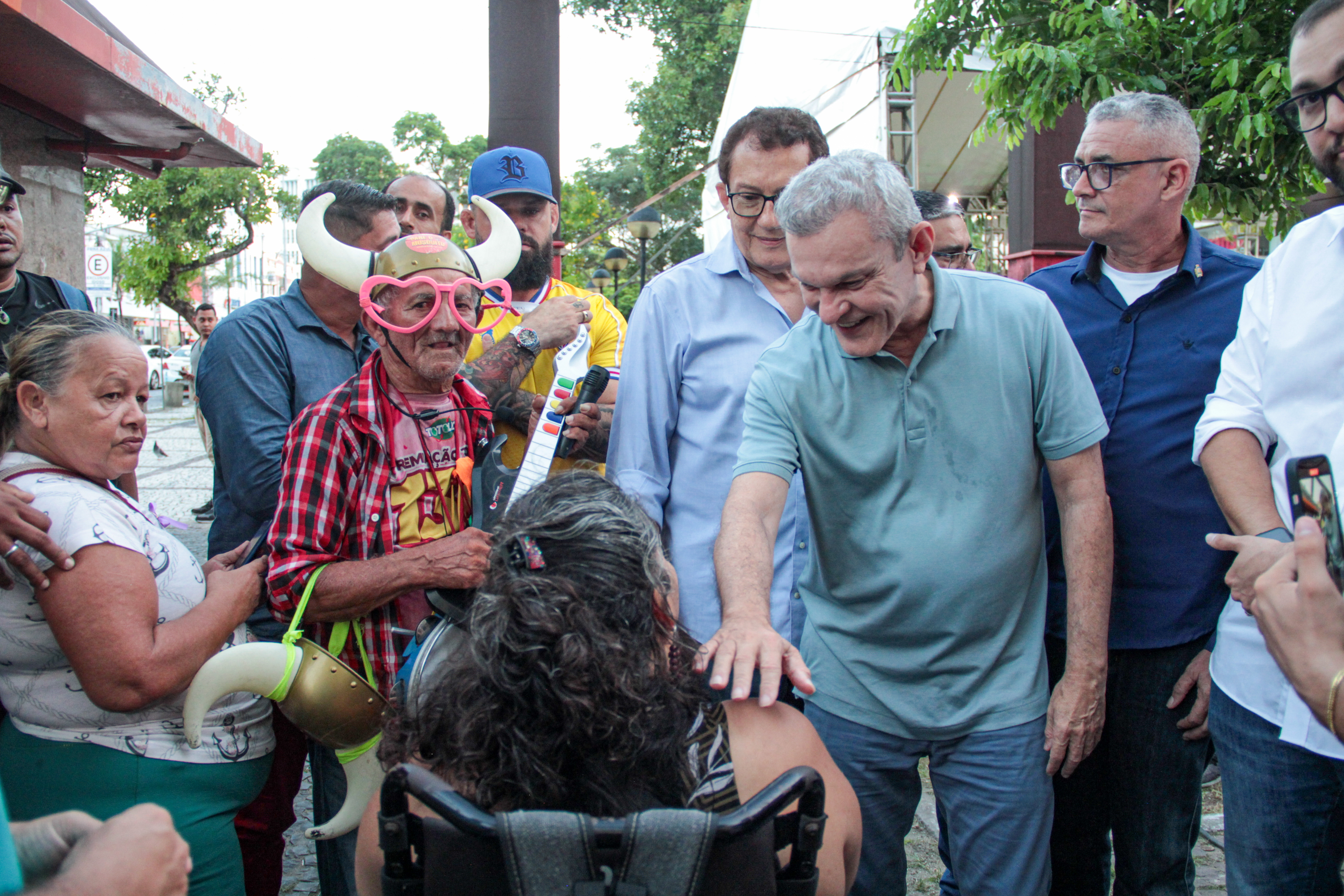 prefeito com a mão no ombro de uma mulher ao lado de outros transeuntes do centro