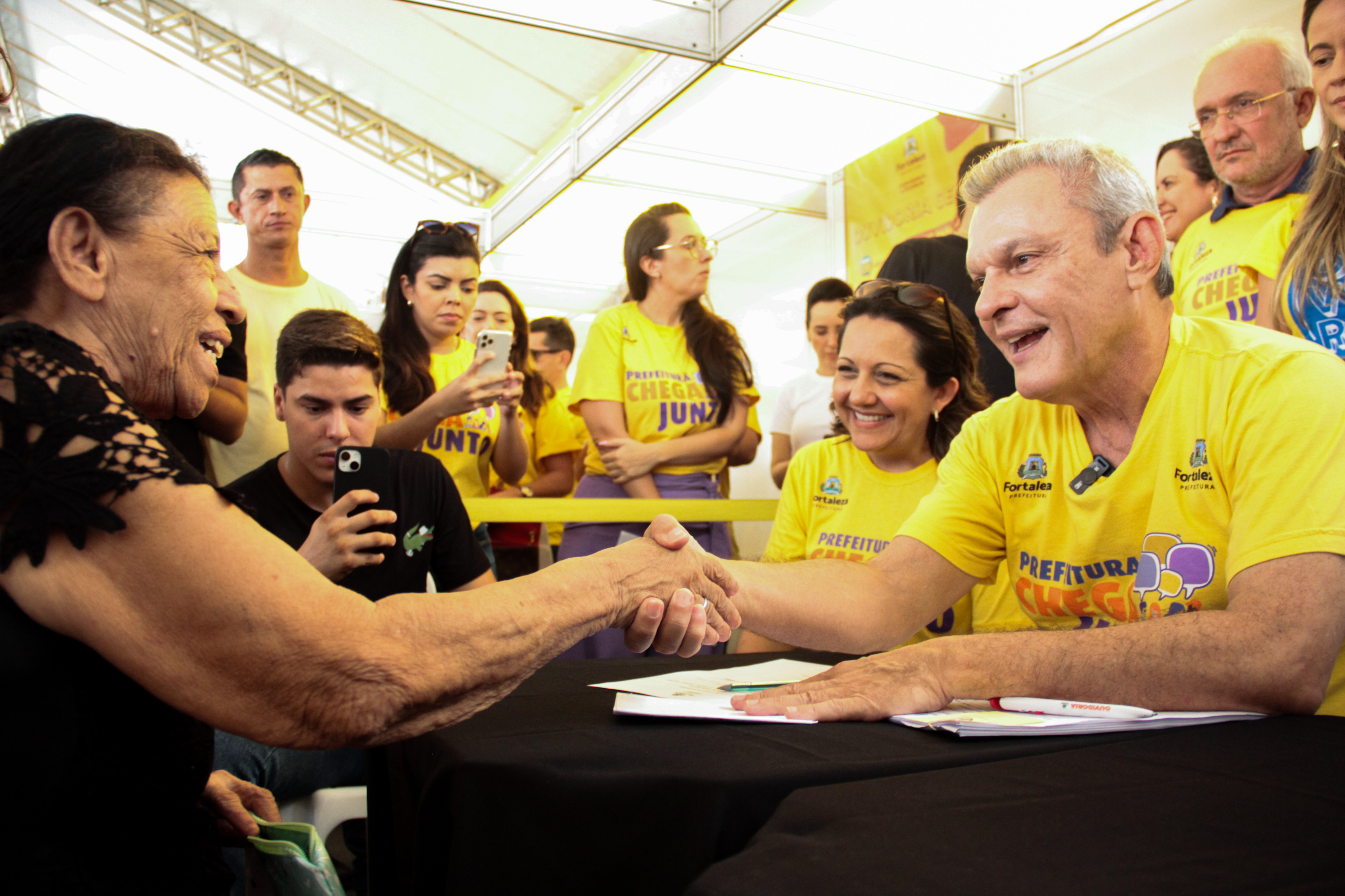 prefeito sorrindo enquanto atende mulher