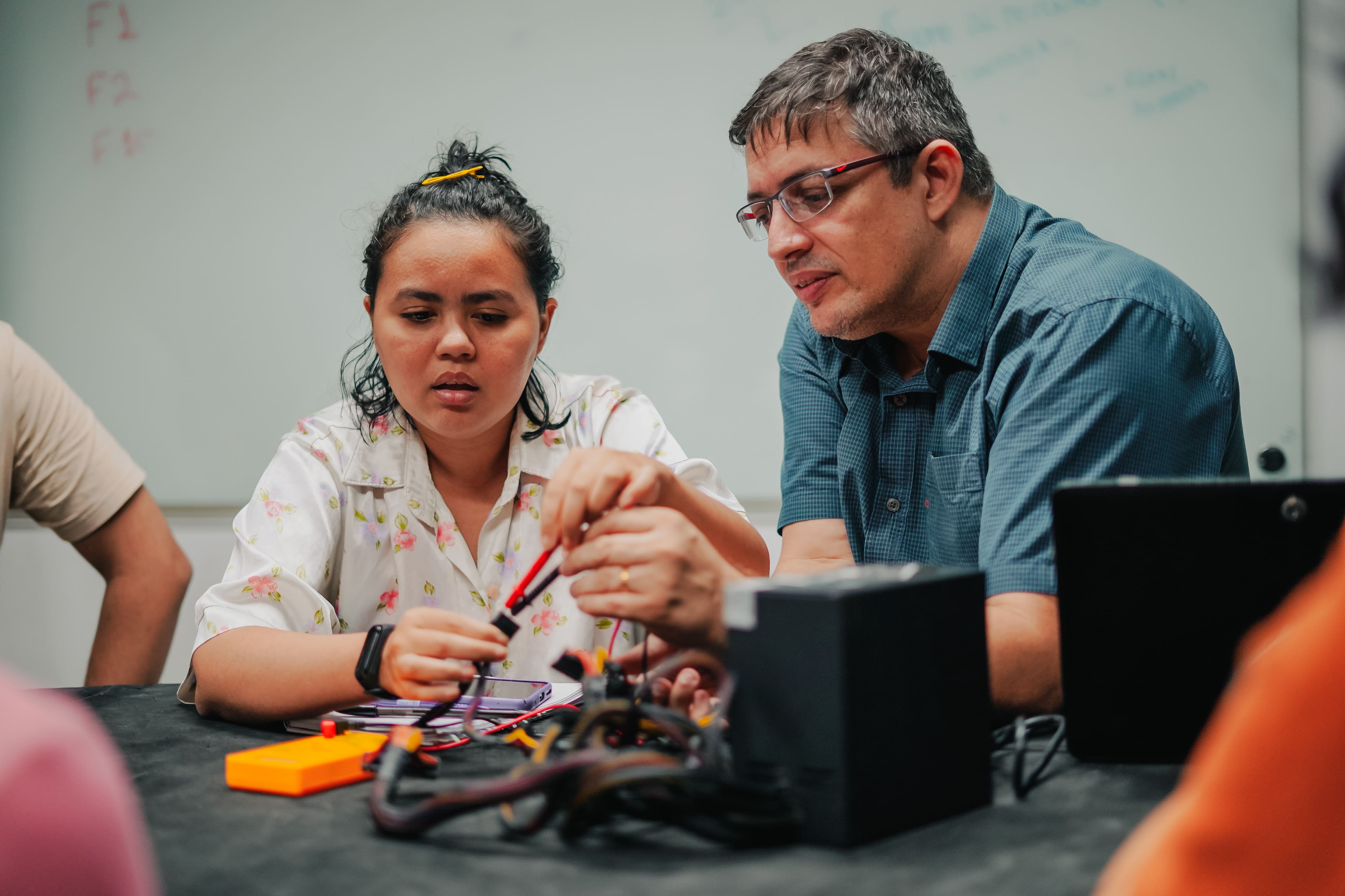 Aluna com professor no curso de manutenção e montagem de computadores