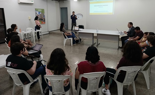 Pessoas reunidas em círculo no auditório