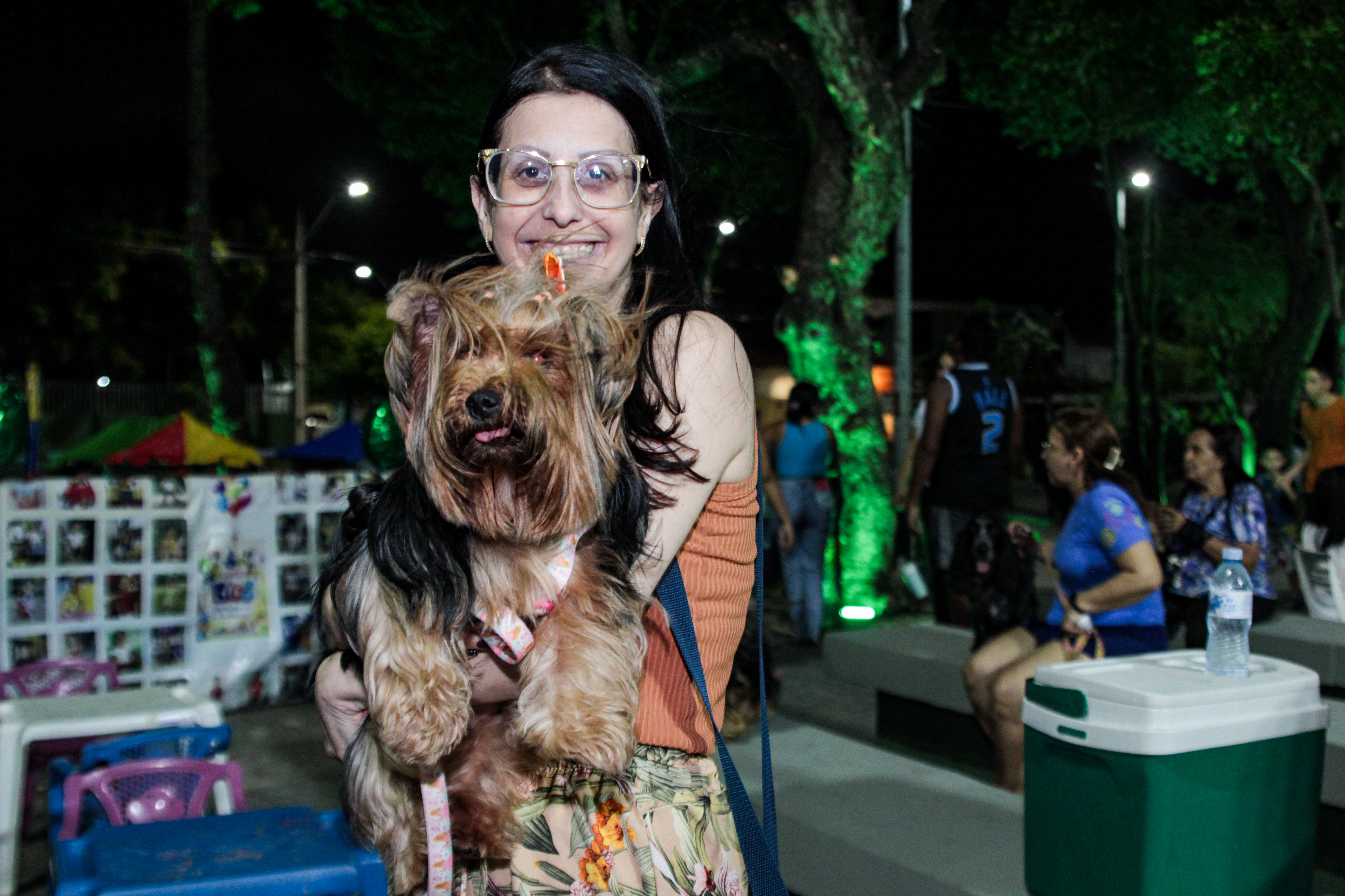 mulher com cachorro da raça yorkshire no colo