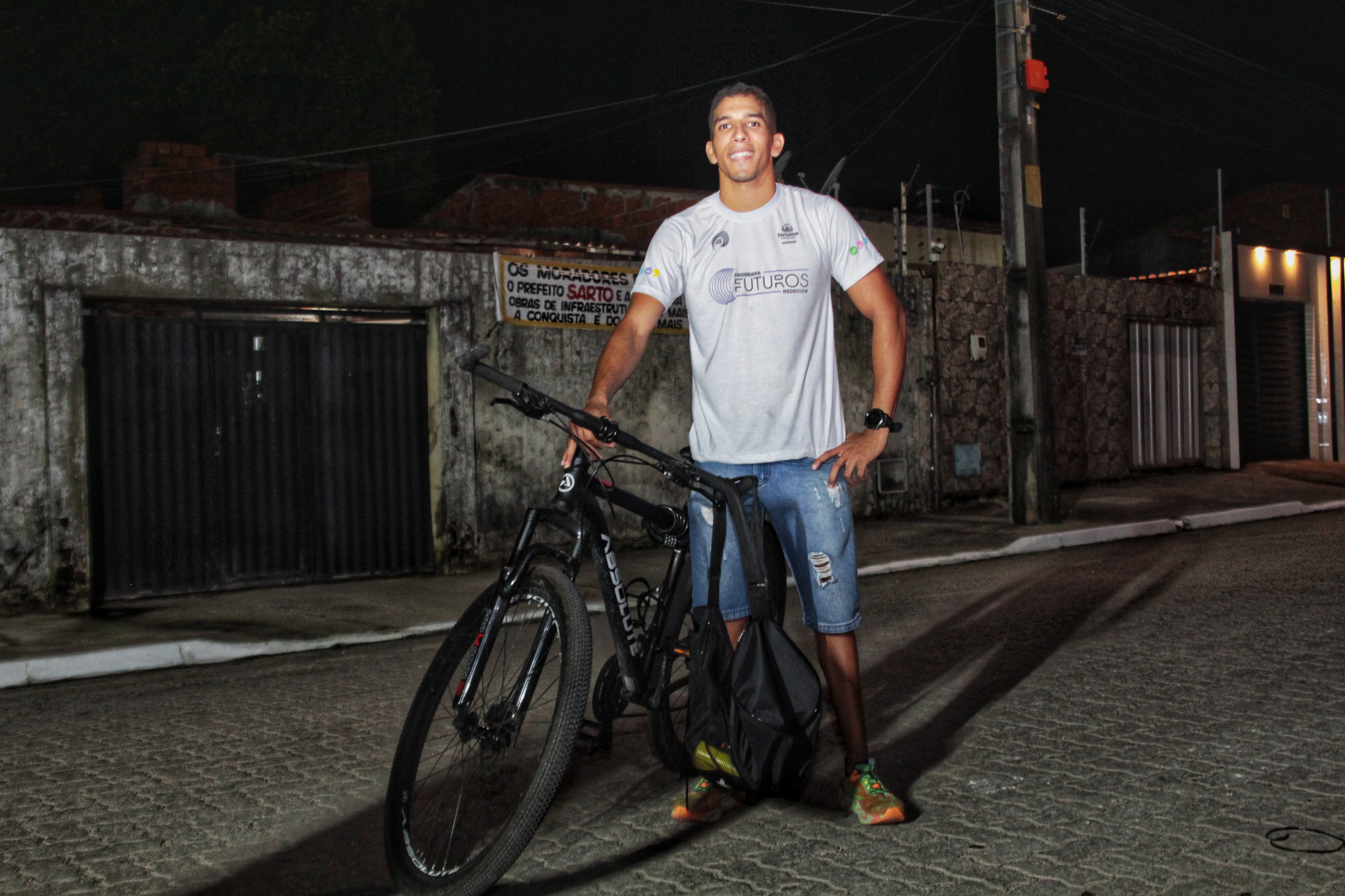 homem na rua segurando bicicleta